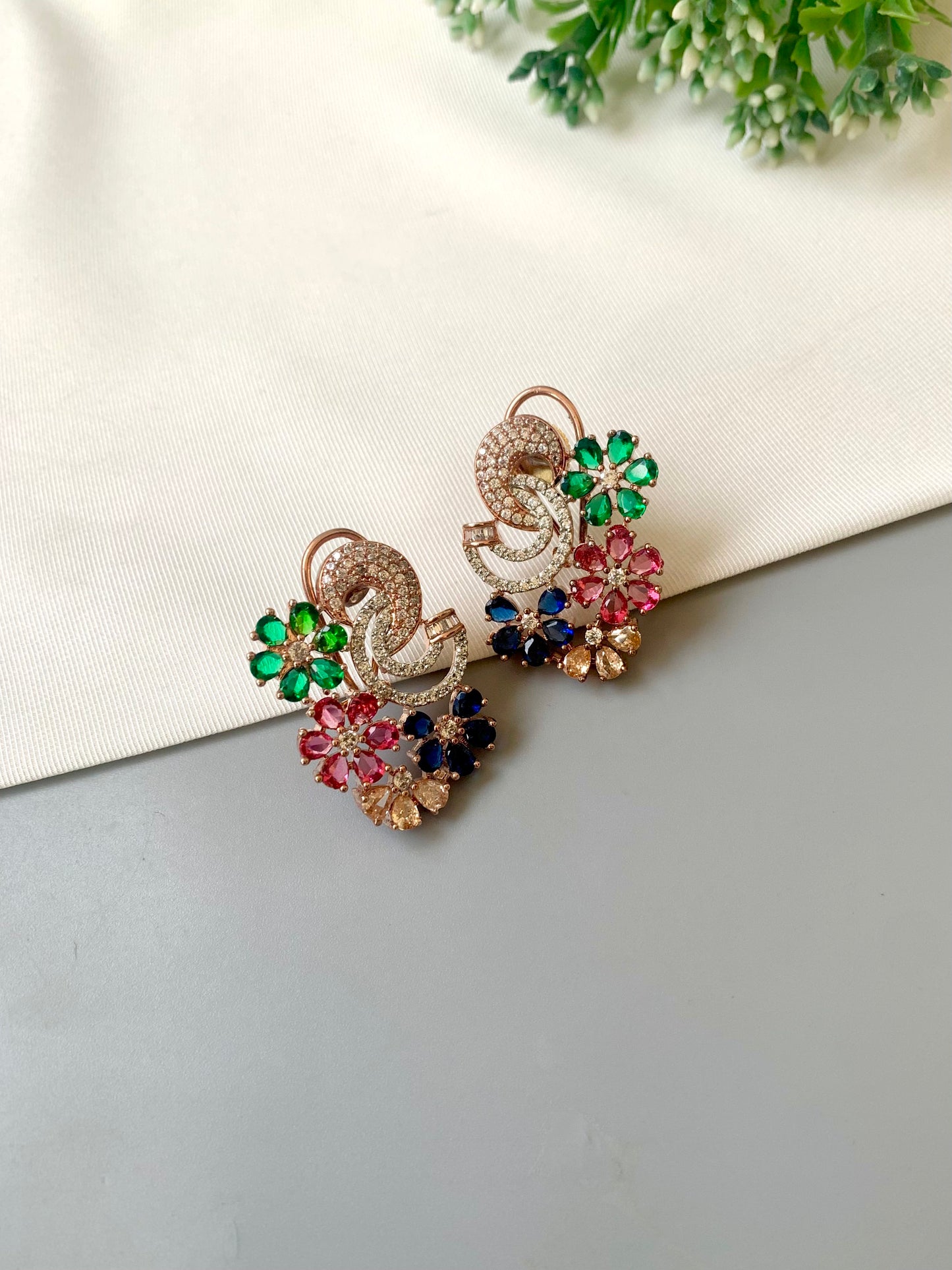Hand crafted Dora studs in 22kt rose gold plating featuring American Diamonds and semi-precious Ruby, Emerald, Sapphire and Champagne stones