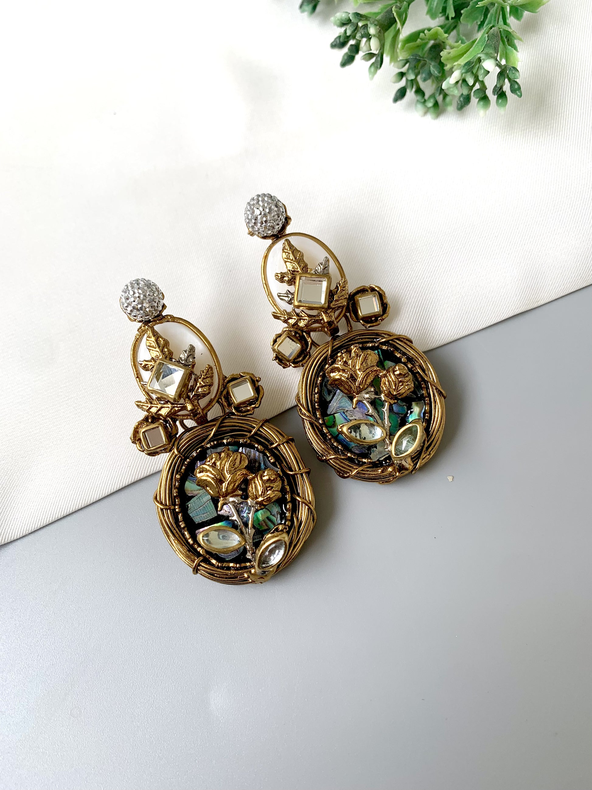 Side angle of Elara Bloom earrings in gold showing American Diamond tops and floral lower frame.
