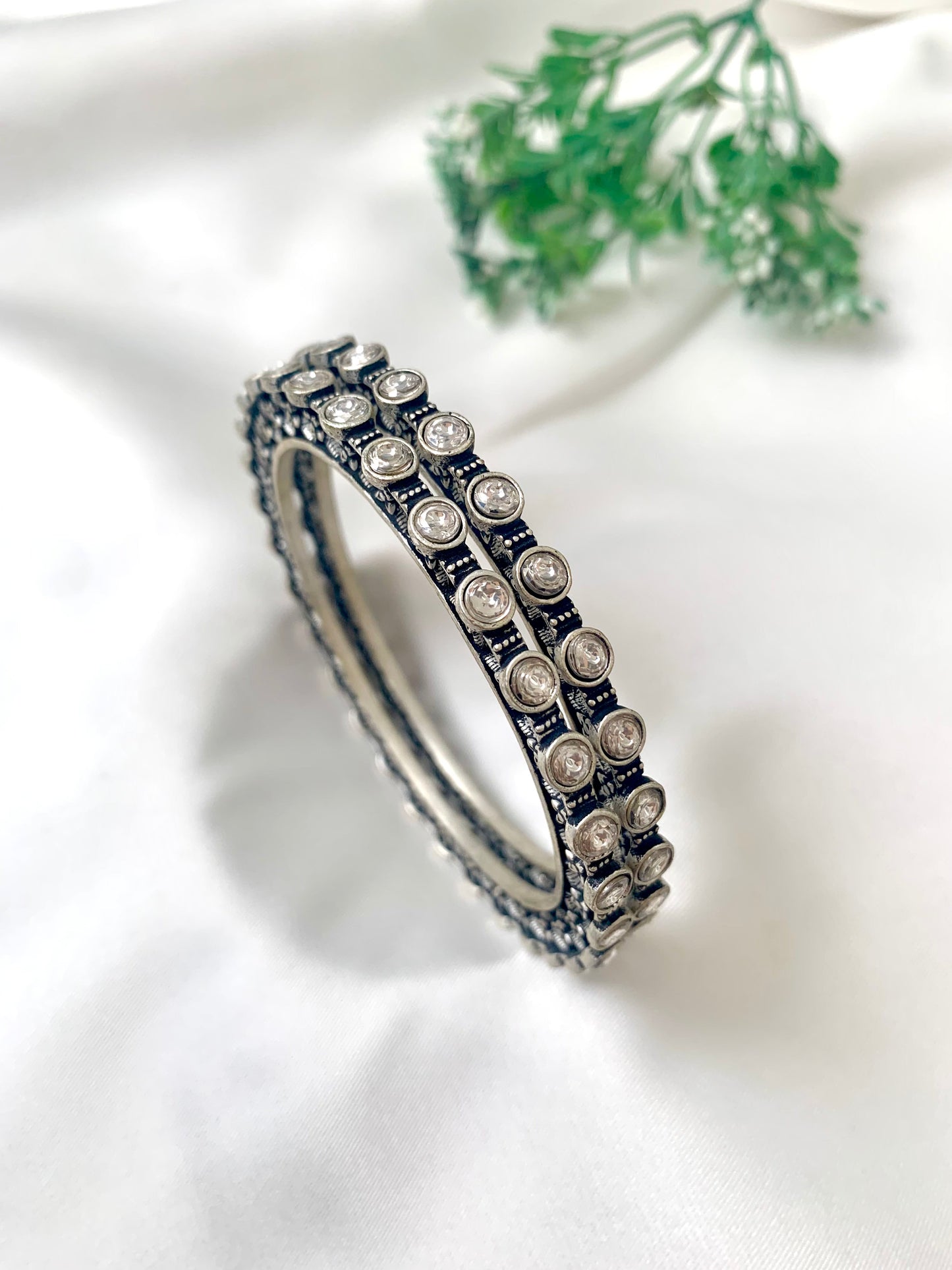 Eve handcrafted rhodium plated bangles with oxidized black polish and high quality Polki Kundan, sold as a pair