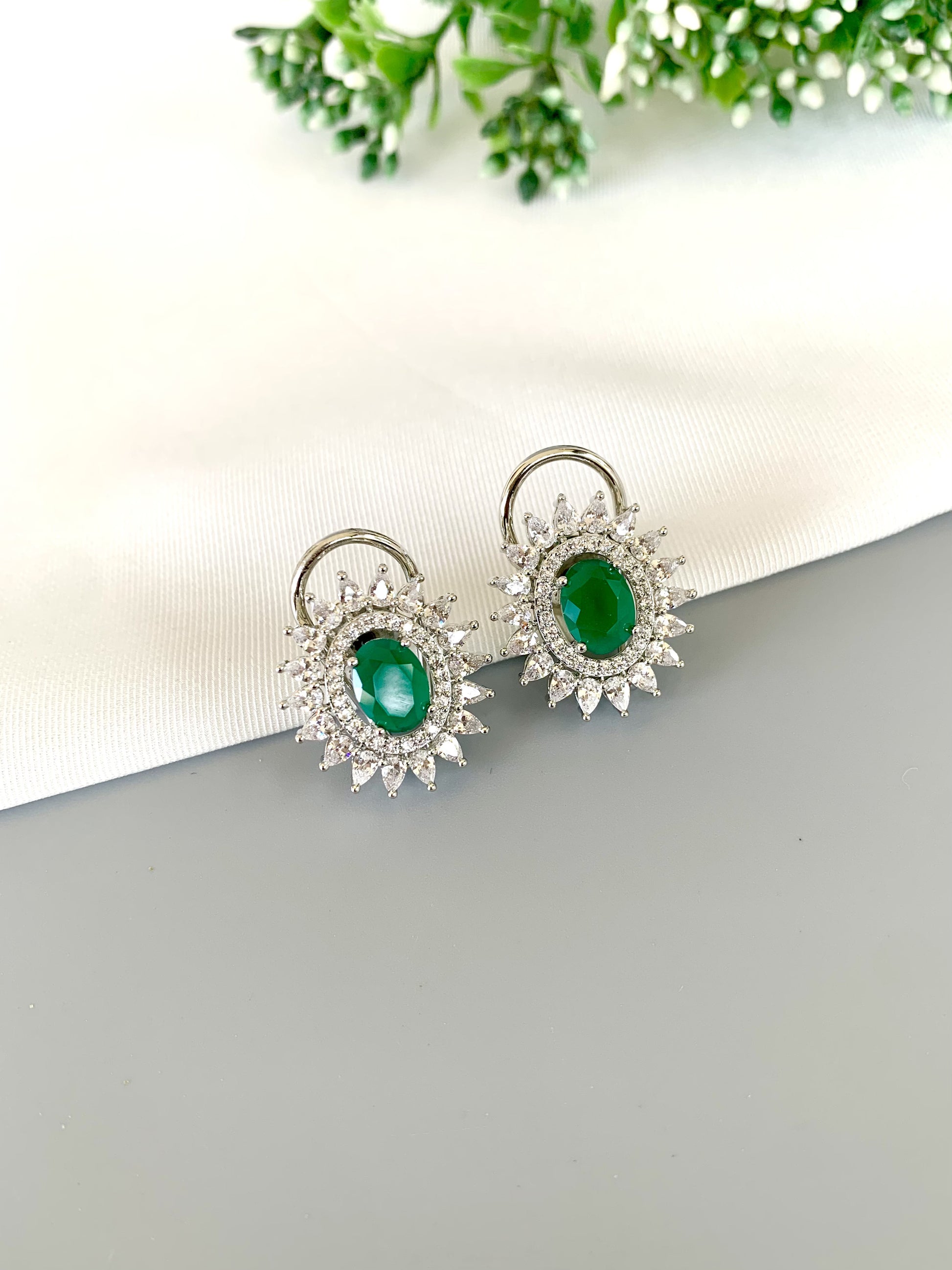Front view of Hermona Emerald Studs in Rhodium plating with American Diamond halo