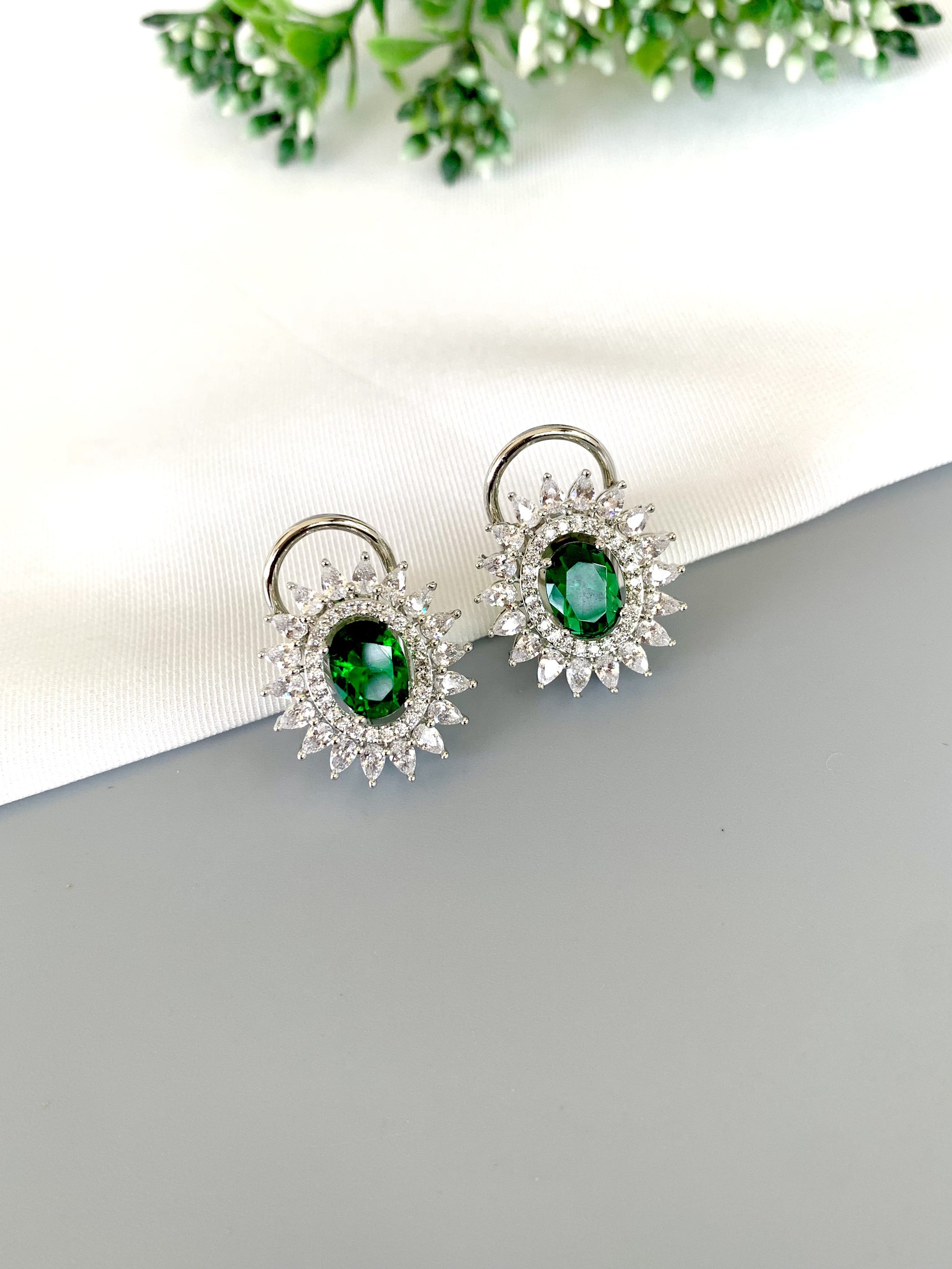 Angled view showing deep green Hydro stone and diamond-studded halo in Rhodium finish
