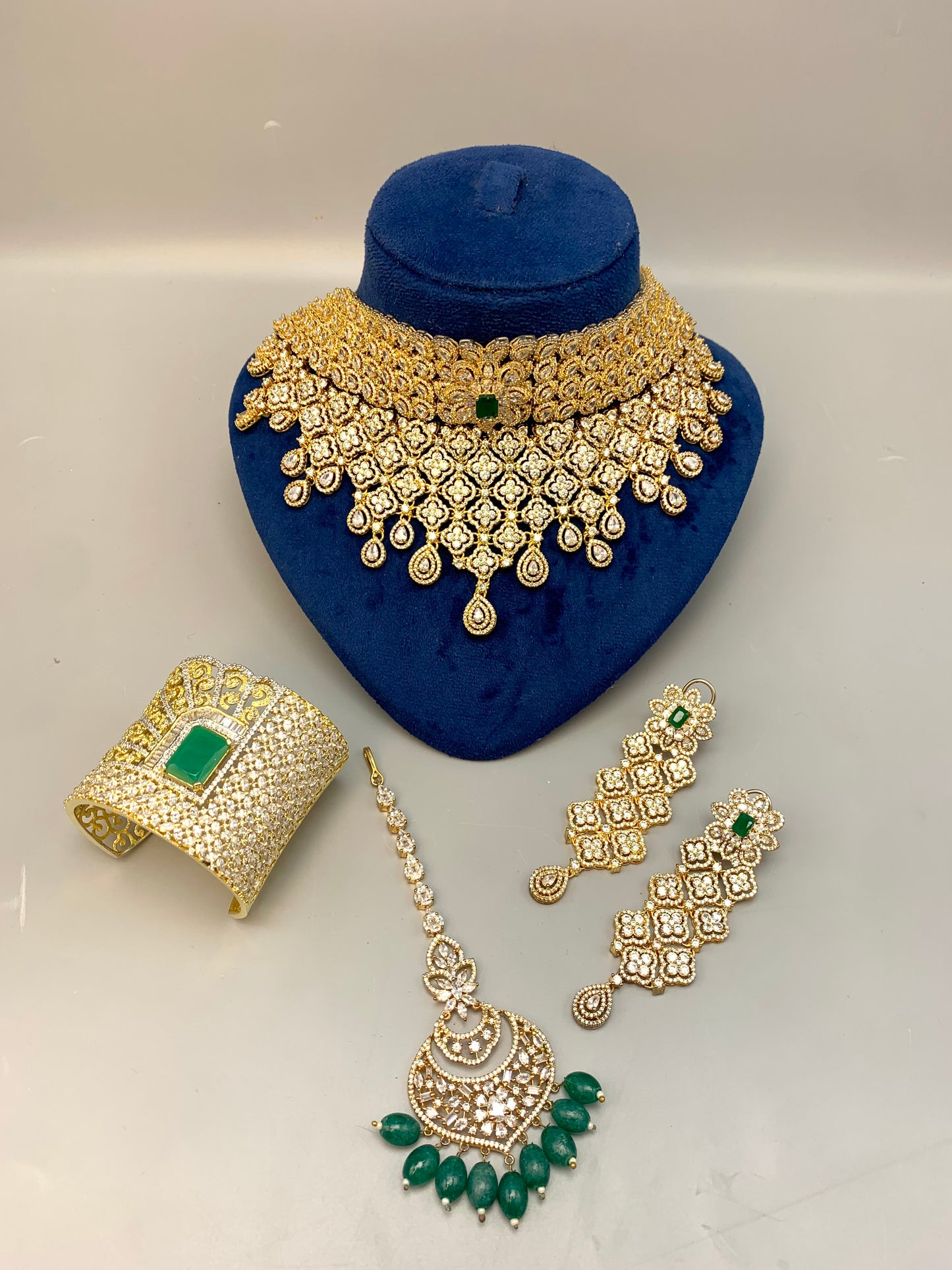 Jamna handcrafted 22kt gold plated bridal set with American Diamonds, semi-precious Emeralds, choker, earrings, tikka and hand cuff