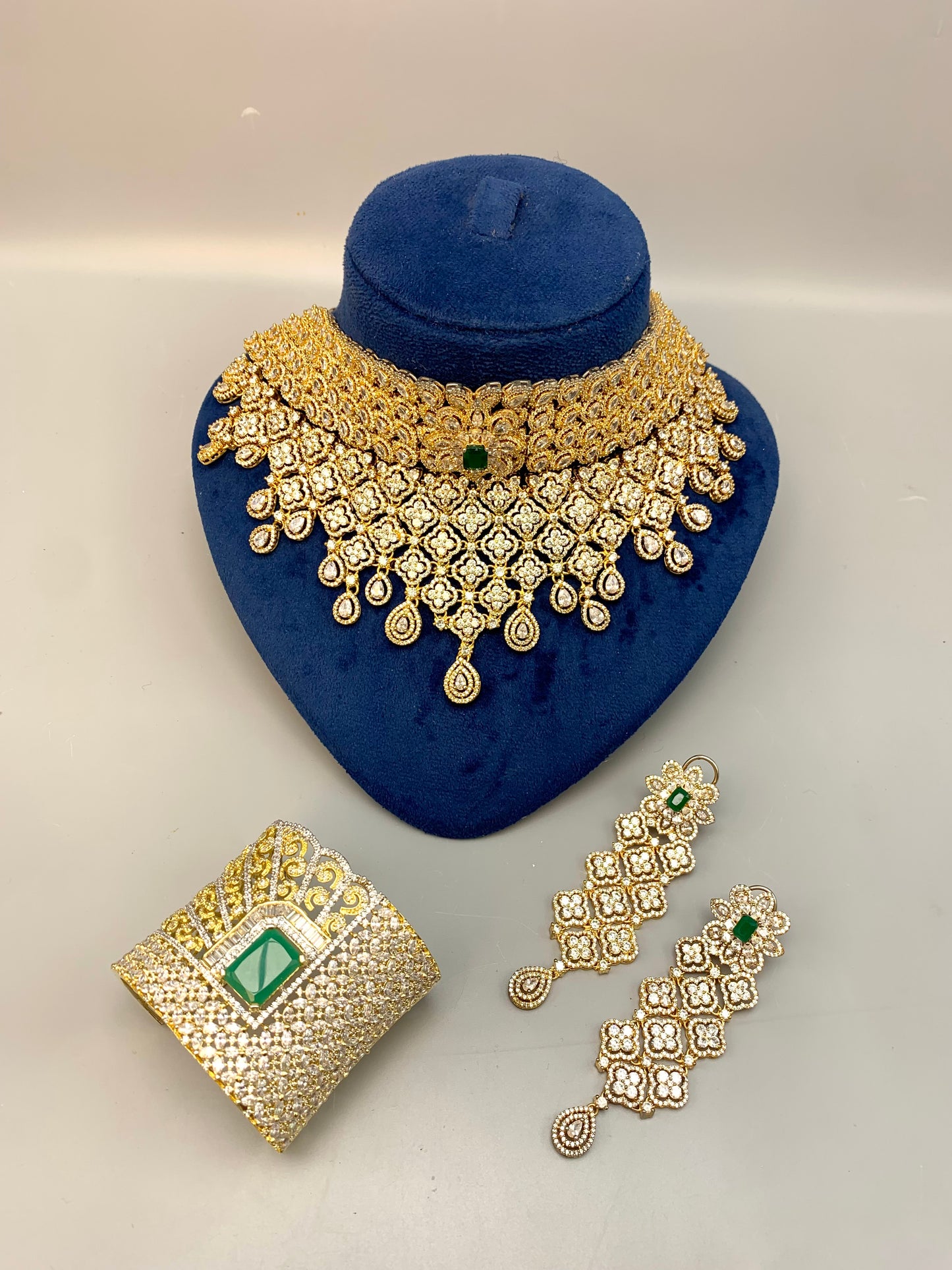 Jamna handcrafted 22kt gold plated bridal set with American Diamonds, semi-precious Emeralds, choker, earrings, tikka and hand cuff