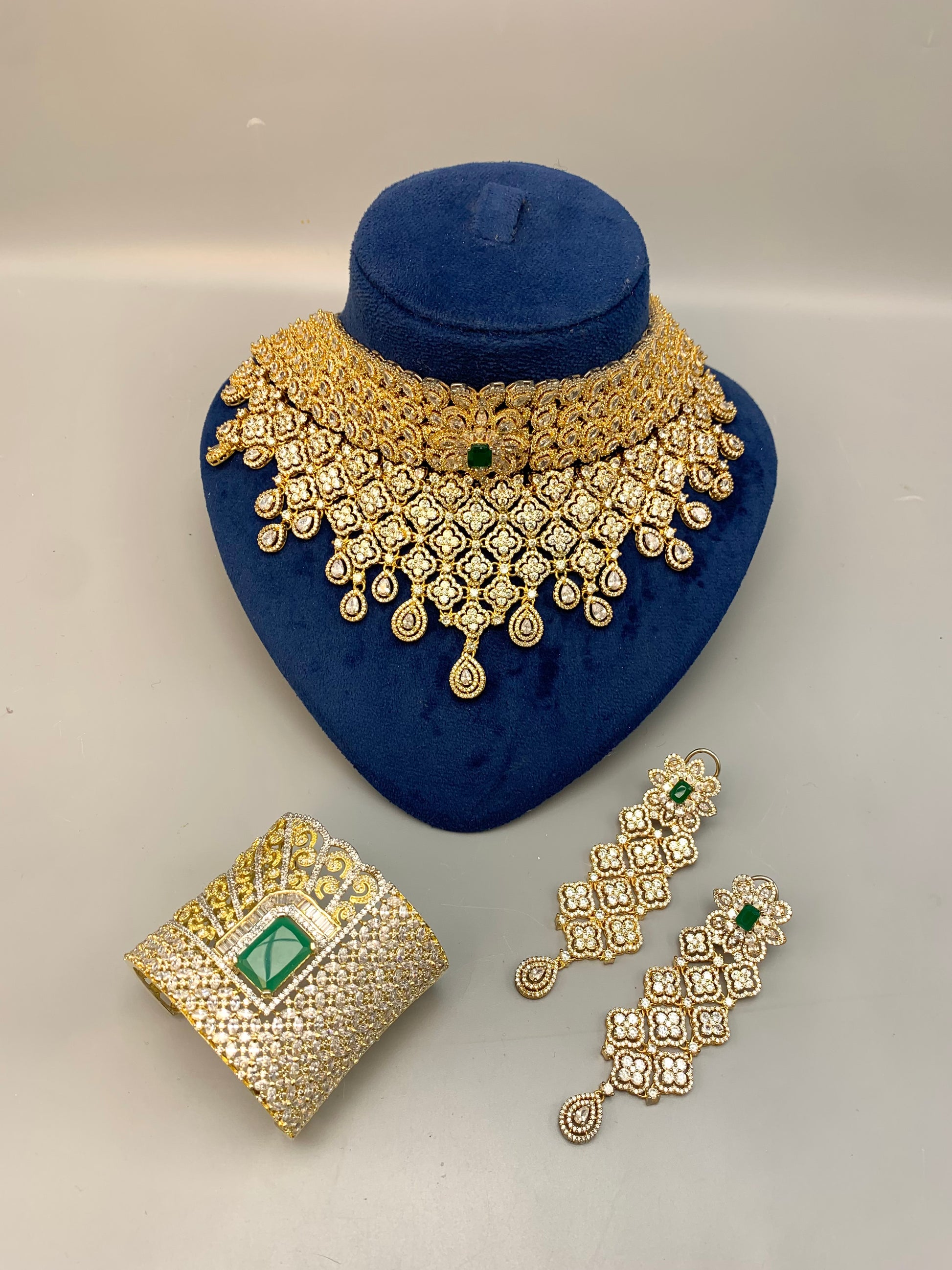 Jamna handcrafted 22kt gold plated bridal set with American Diamonds, semi-precious Emeralds, choker, earrings, tikka and hand cuff