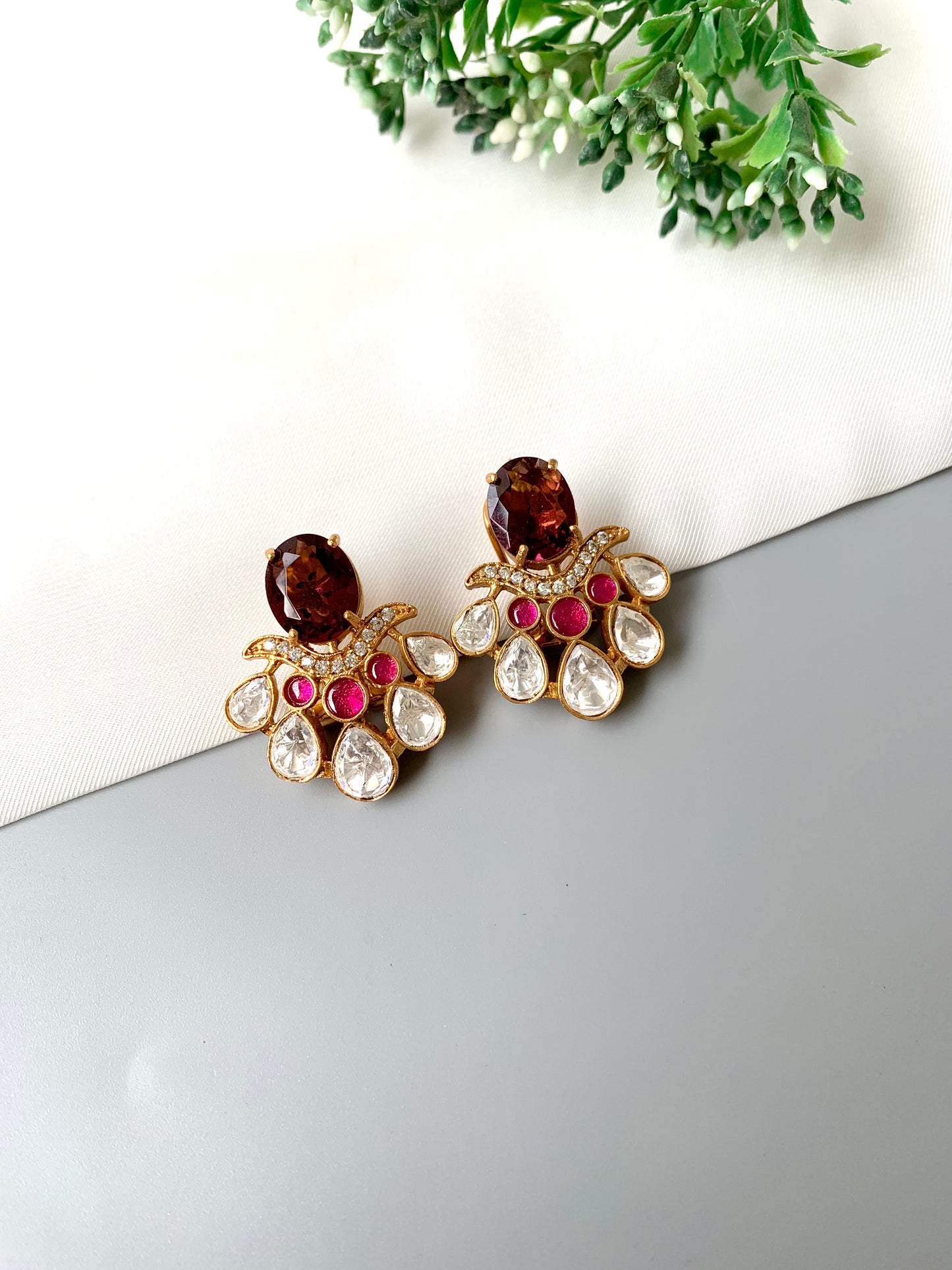 Close-up detail of Kavia Amethyst handcrafted earrings showcasing teardrop American Diamonds and ruby accents.