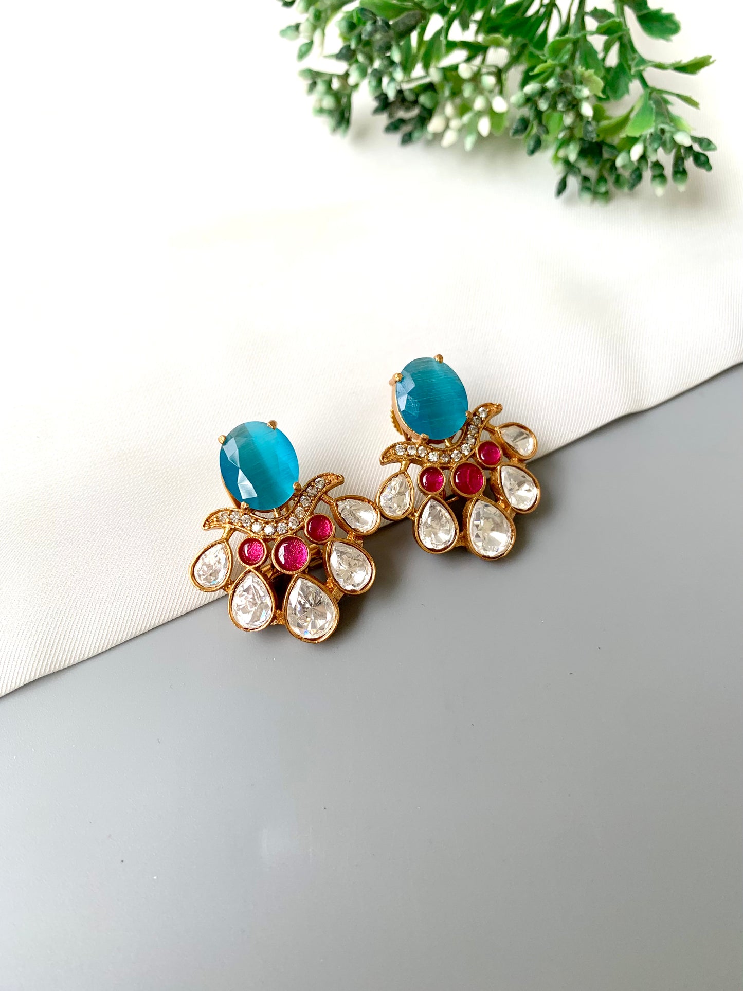 Close-up image of Kavia Feroza earrings showing teardrop American Diamonds and blue Feroza centerpiece.