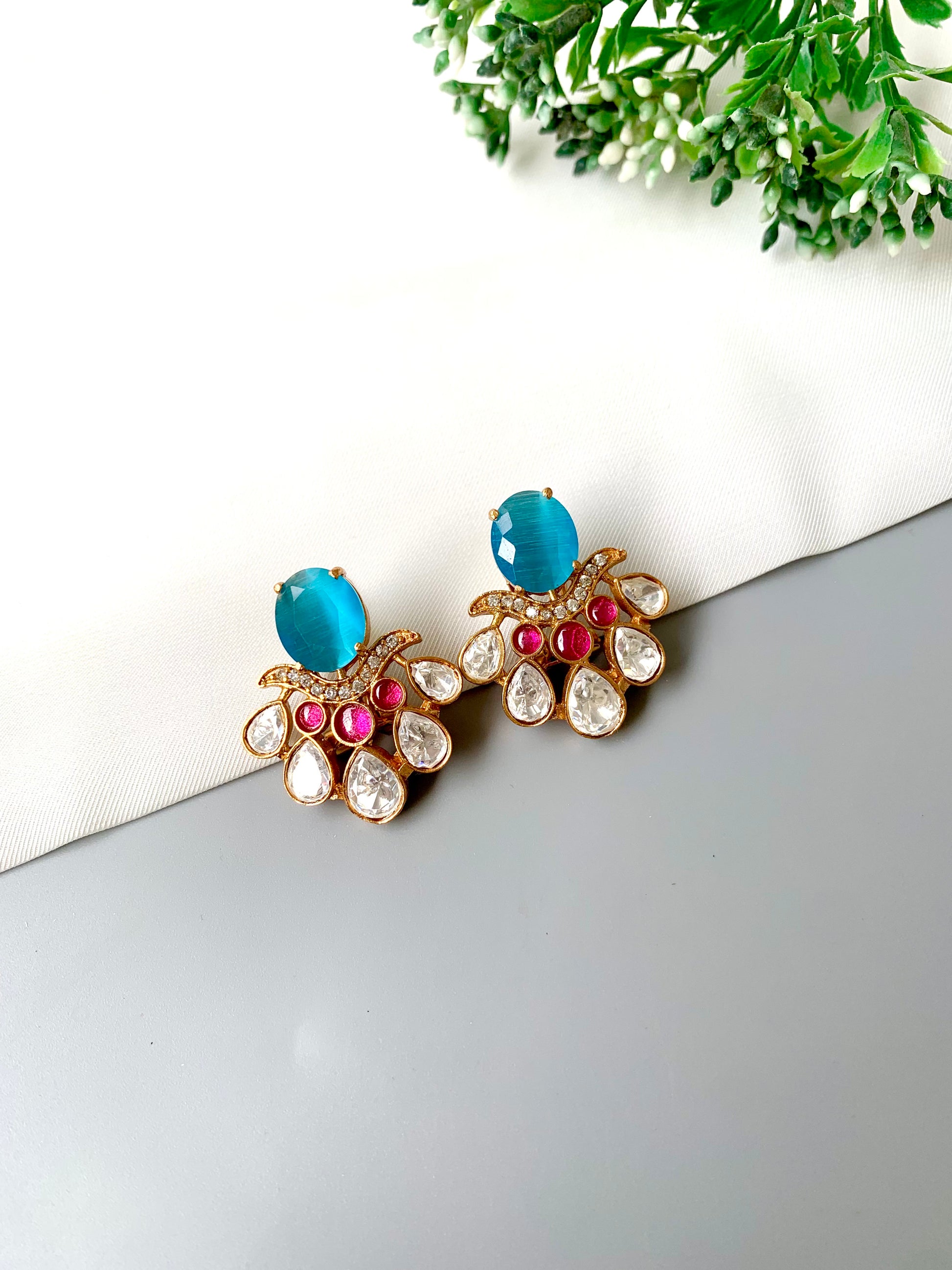 Top-angle shot of Kavia Feroza earrings with vibrant blue Feroza stone and gold finish.