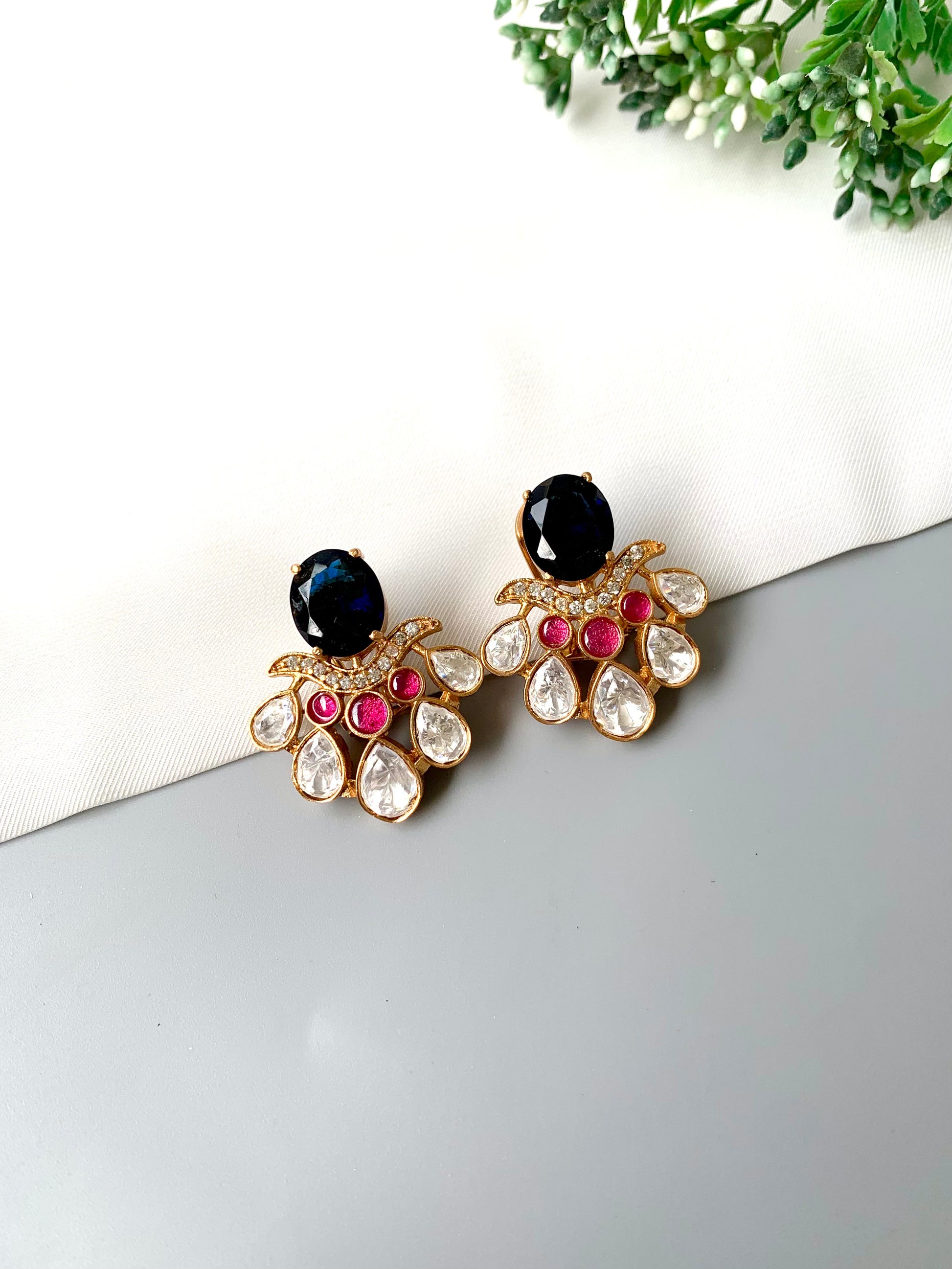 Close-up view of Kavia Sapphire earrings showing American Diamond teardrops and sapphire centerpiece.