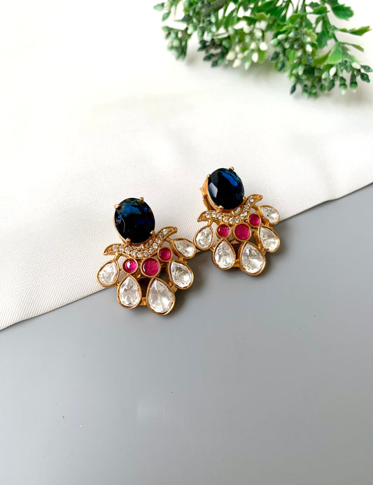 Front view of Kavia Sapphire earrings with dark blue Sapphire, ruby accents, and Polki Kundan in 22kt gold.