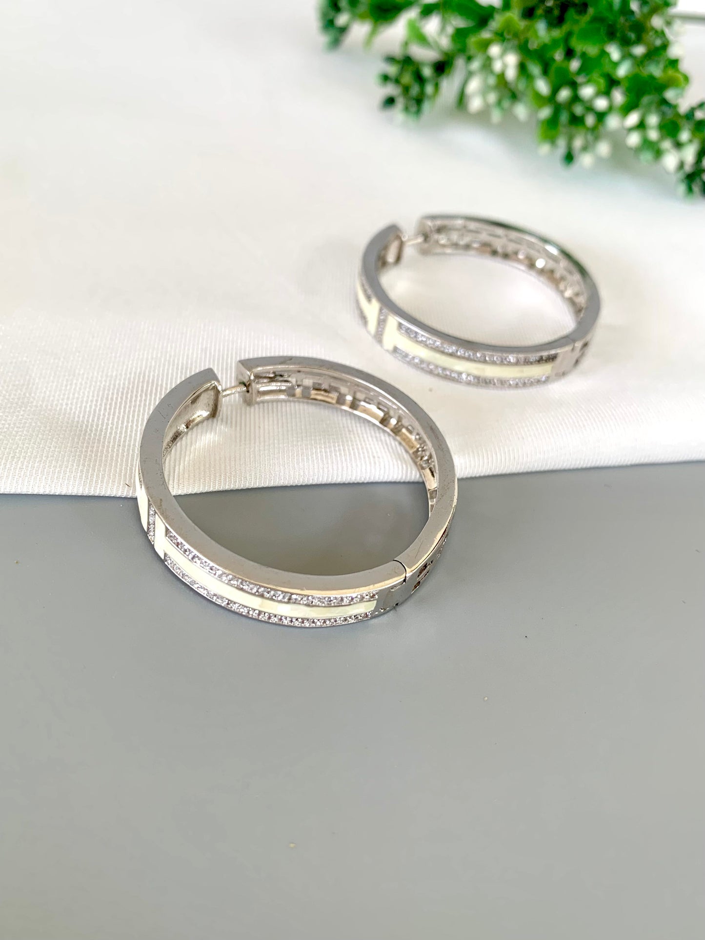 liora-rhodium-hoops-closeup-zamaljewels.jpg
Close-up shot highlighting the shine of the Rhodium finish and Mother of Pearl paneling