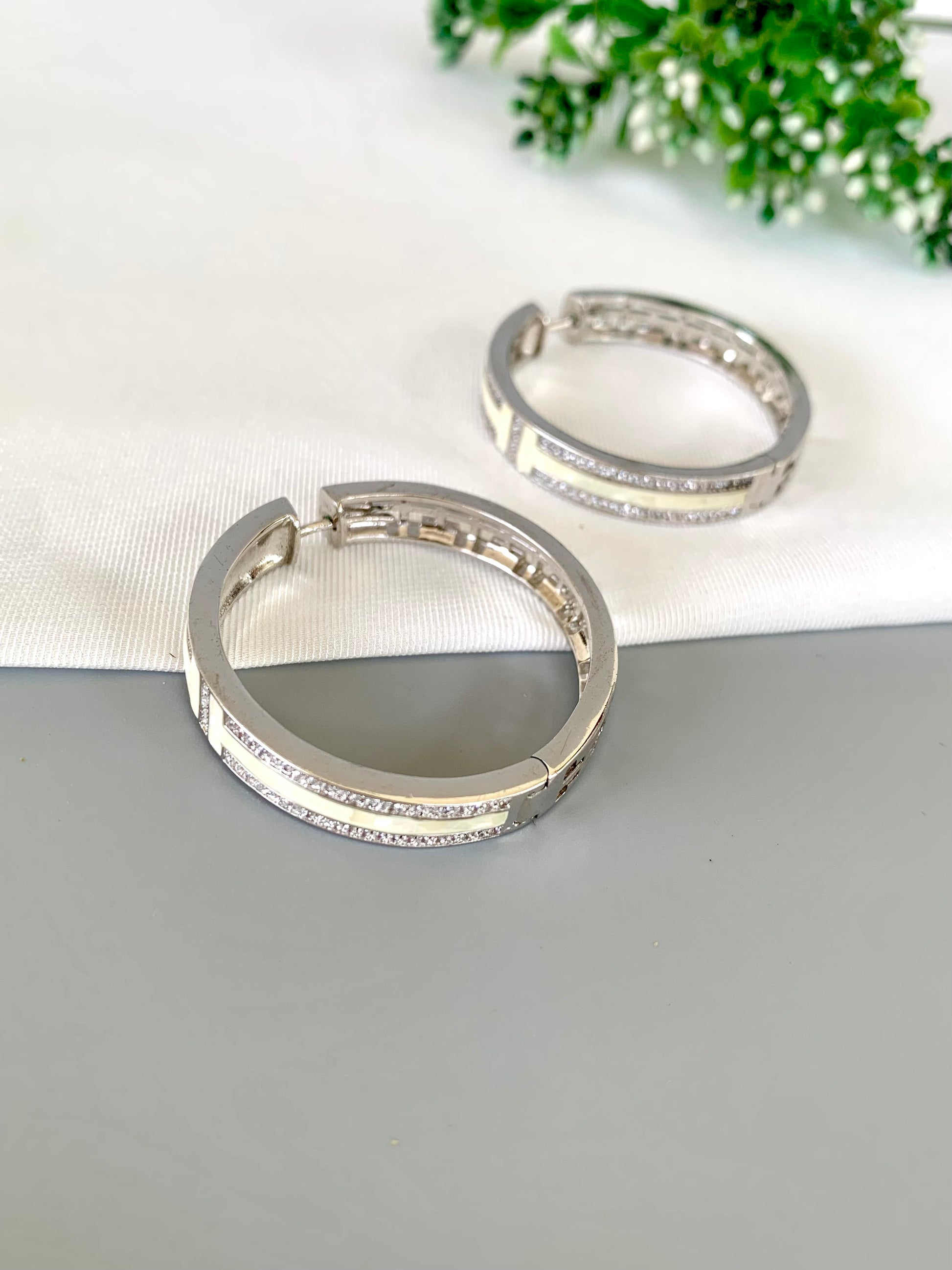 liora-rhodium-hoops-closeup-zamaljewels.jpg
Close-up shot highlighting the shine of the Rhodium finish and Mother of Pearl paneling