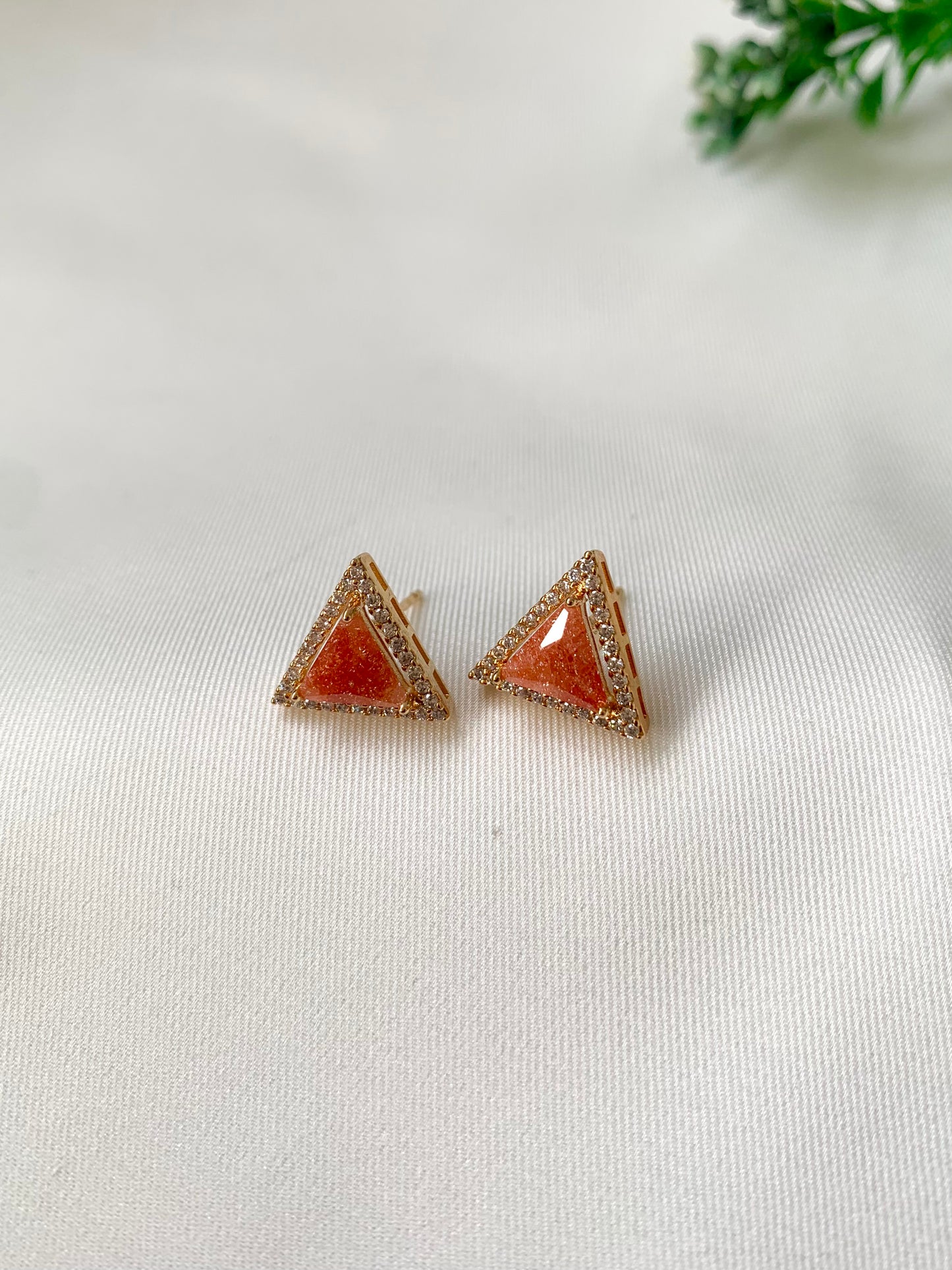 Delicate triangular Lumi studs in 22kt gold plating with American Diamonds and pastel orange natural milky stone