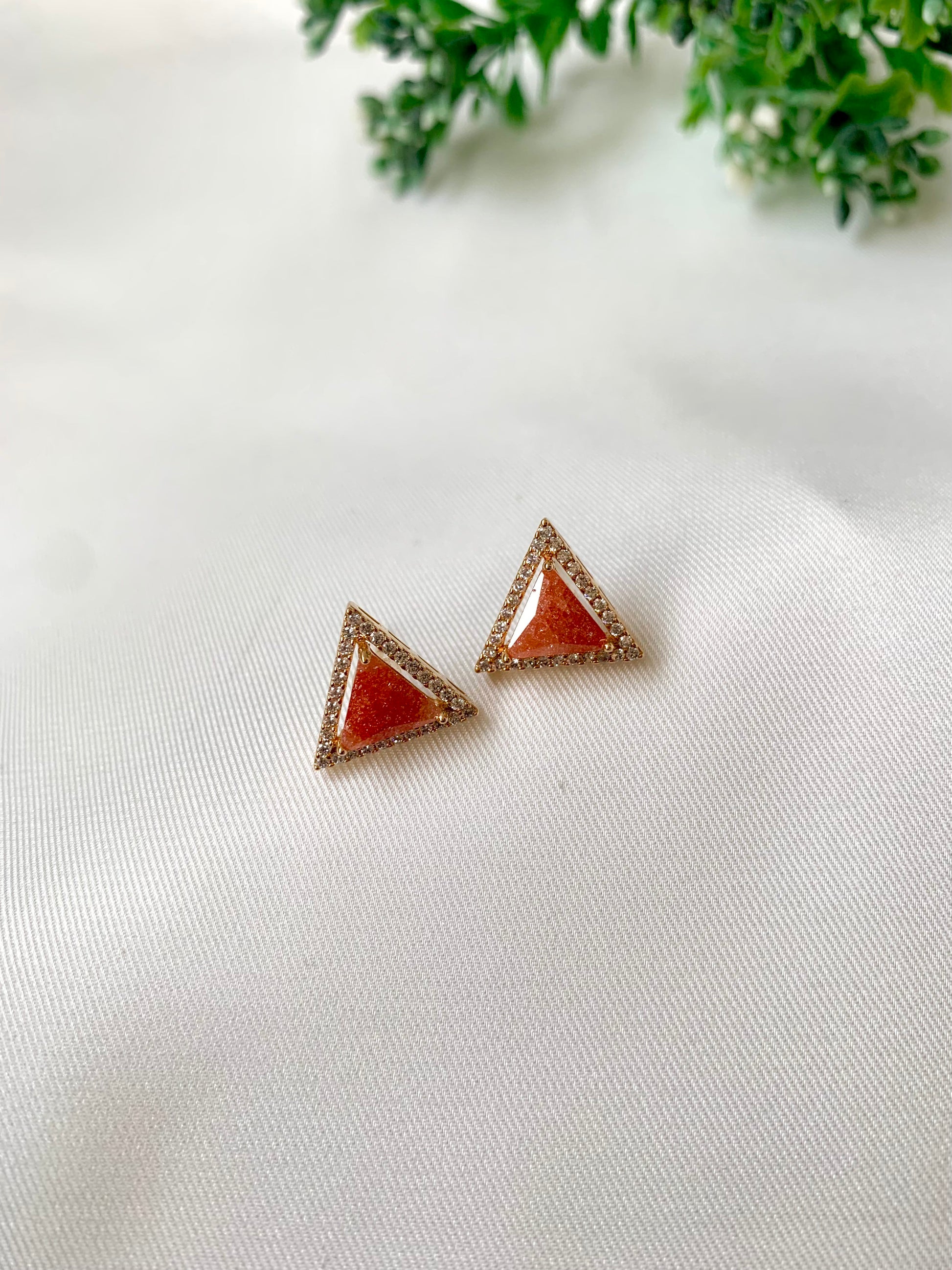Delicate triangular Lumi studs in 22kt gold plating with American Diamonds and pastel orange natural milky stone