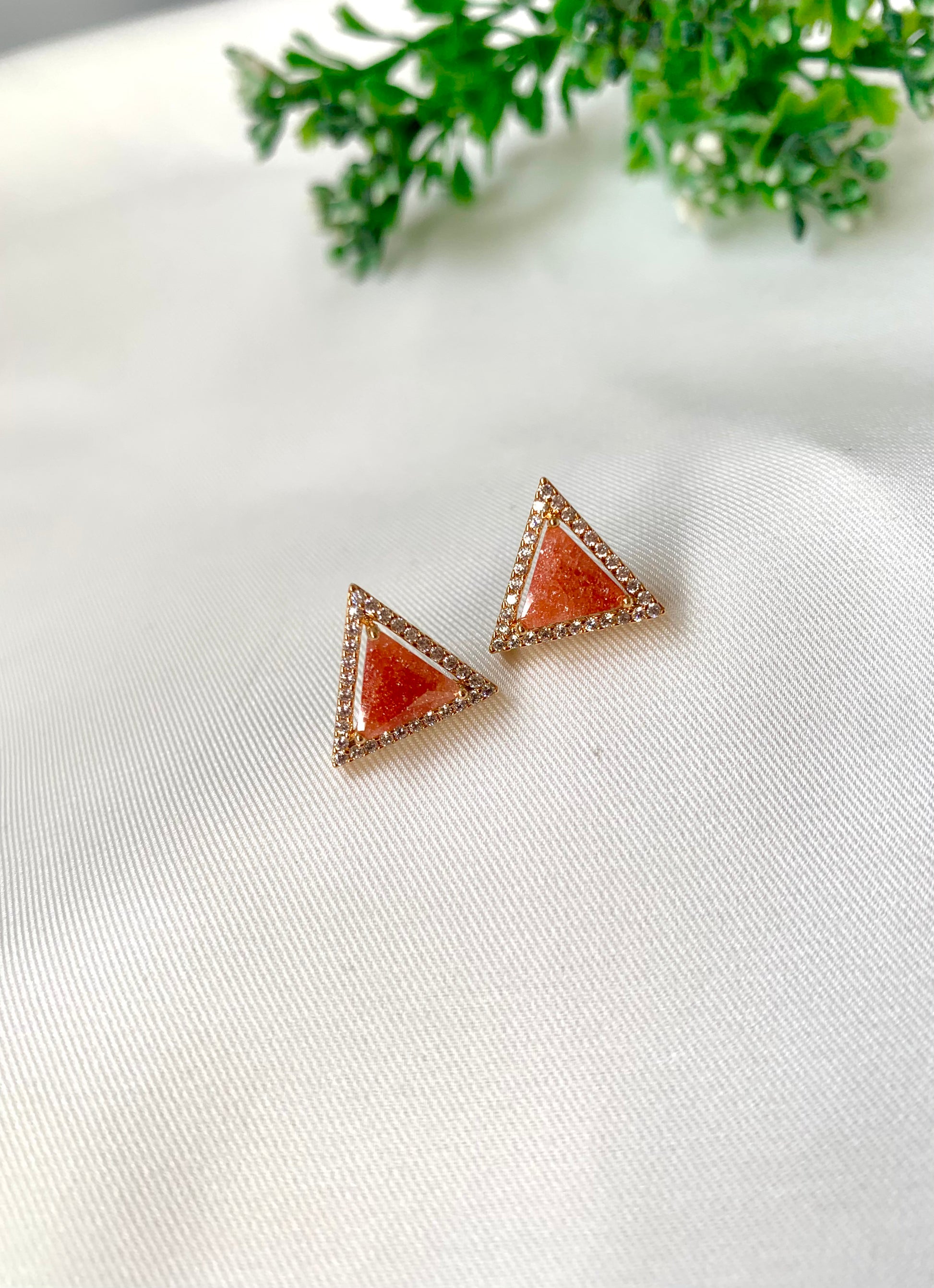 Delicate triangular Lumi studs in 22kt gold plating with American Diamonds and pastel orange natural milky stone