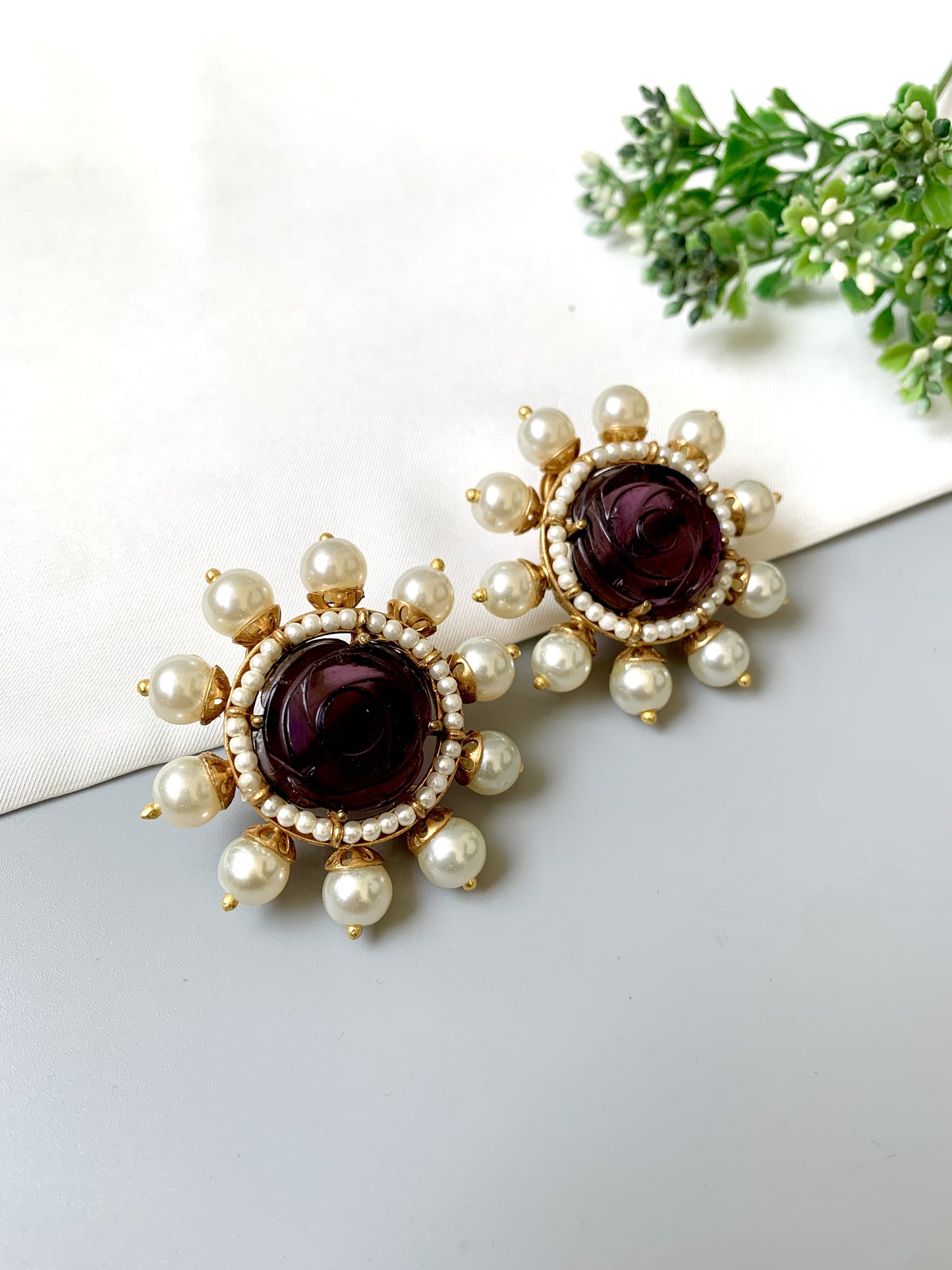 Close-up of Mehr Studs by Zamal Jewels with semi-precious amethyst and pearls in gold finish