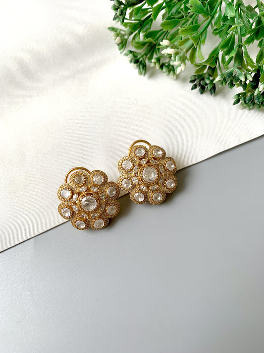Flat lay image of Mehra floral studs in 22kt gold with Moissanite diamonds in a cluster design
