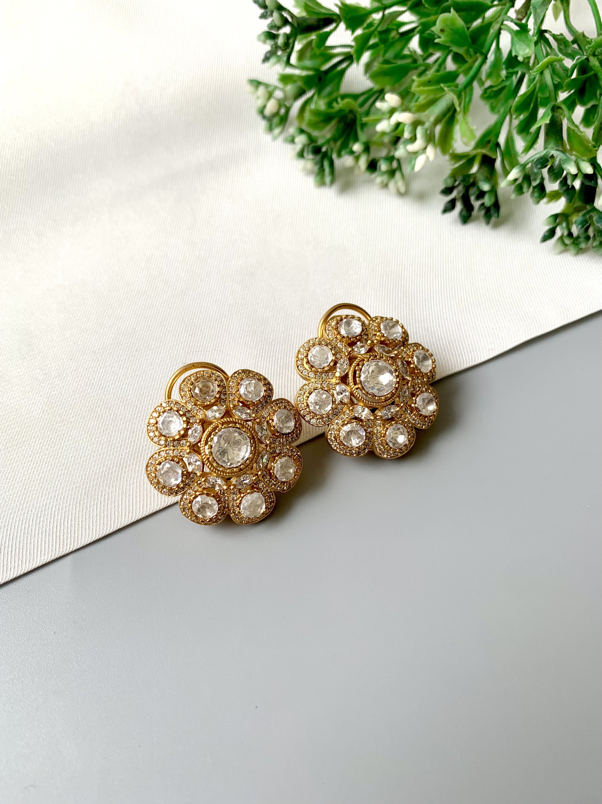 Close-up of Mehra earrings featuring Moissanite diamonds in a radiant floral cluster with 22kt gold finish