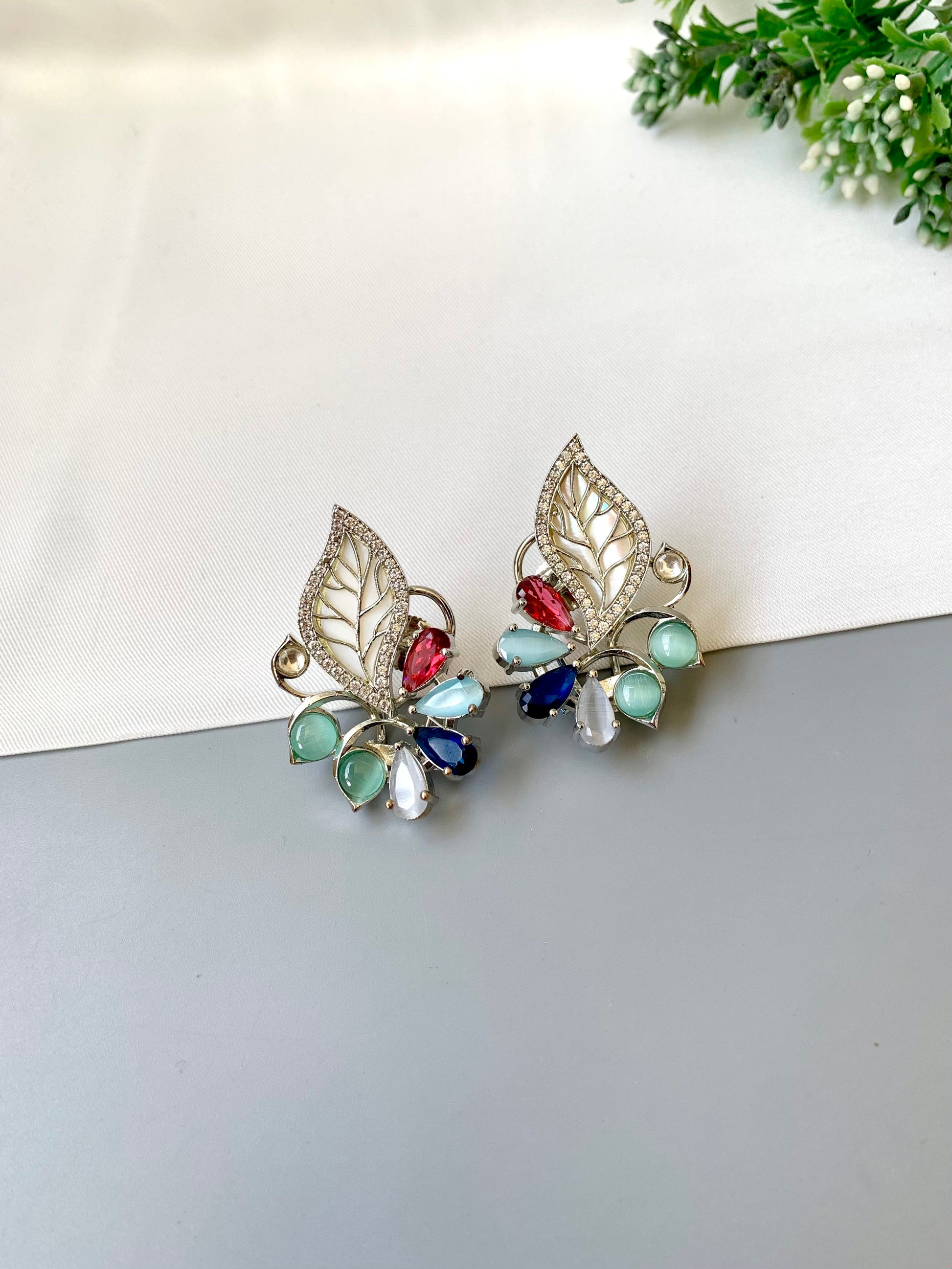 Mila designer studs in rhodium platinum finish with mother of pearl and ruby sapphire onyx gemstones