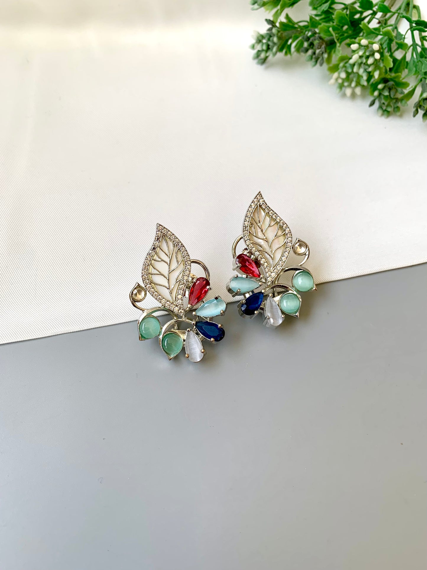 Mila designer studs in rhodium platinum finish with mother of pearl and ruby sapphire onyx gemstones