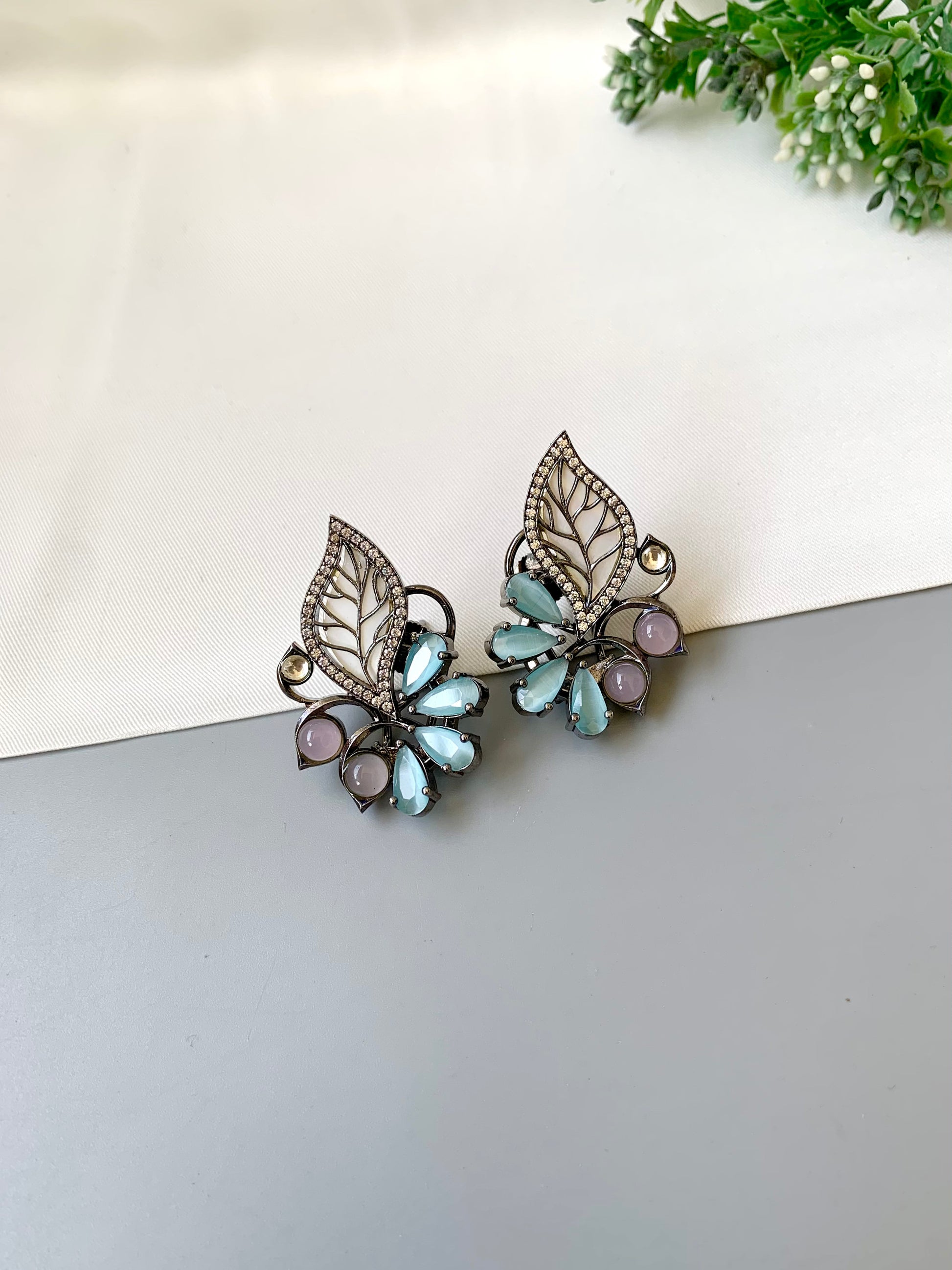 Mina polki kundan studs in rhodium oxidized finish with mother of pearl and onyx stones