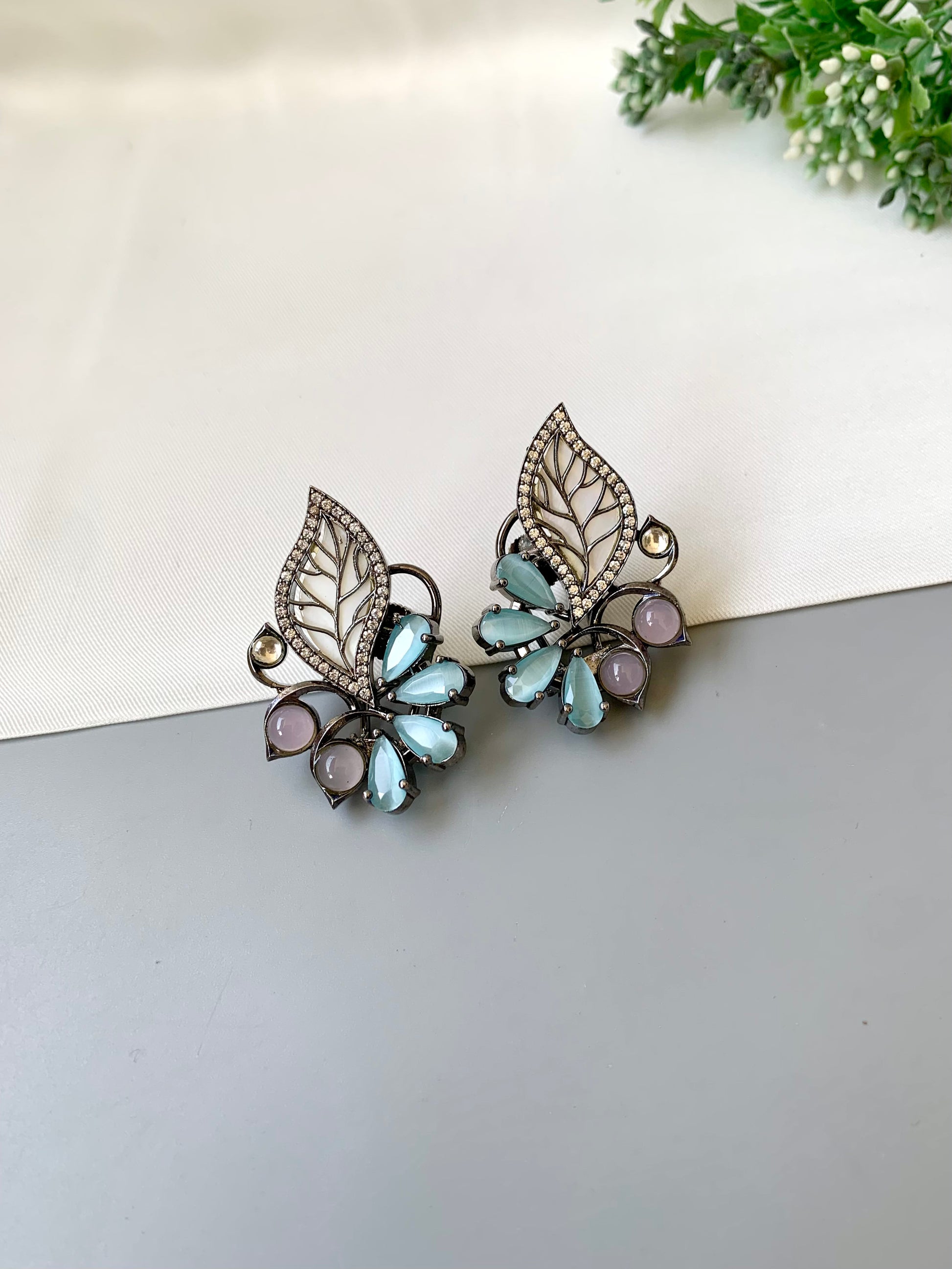Mina polki kundan studs in rhodium oxidized finish with mother of pearl and onyx stones