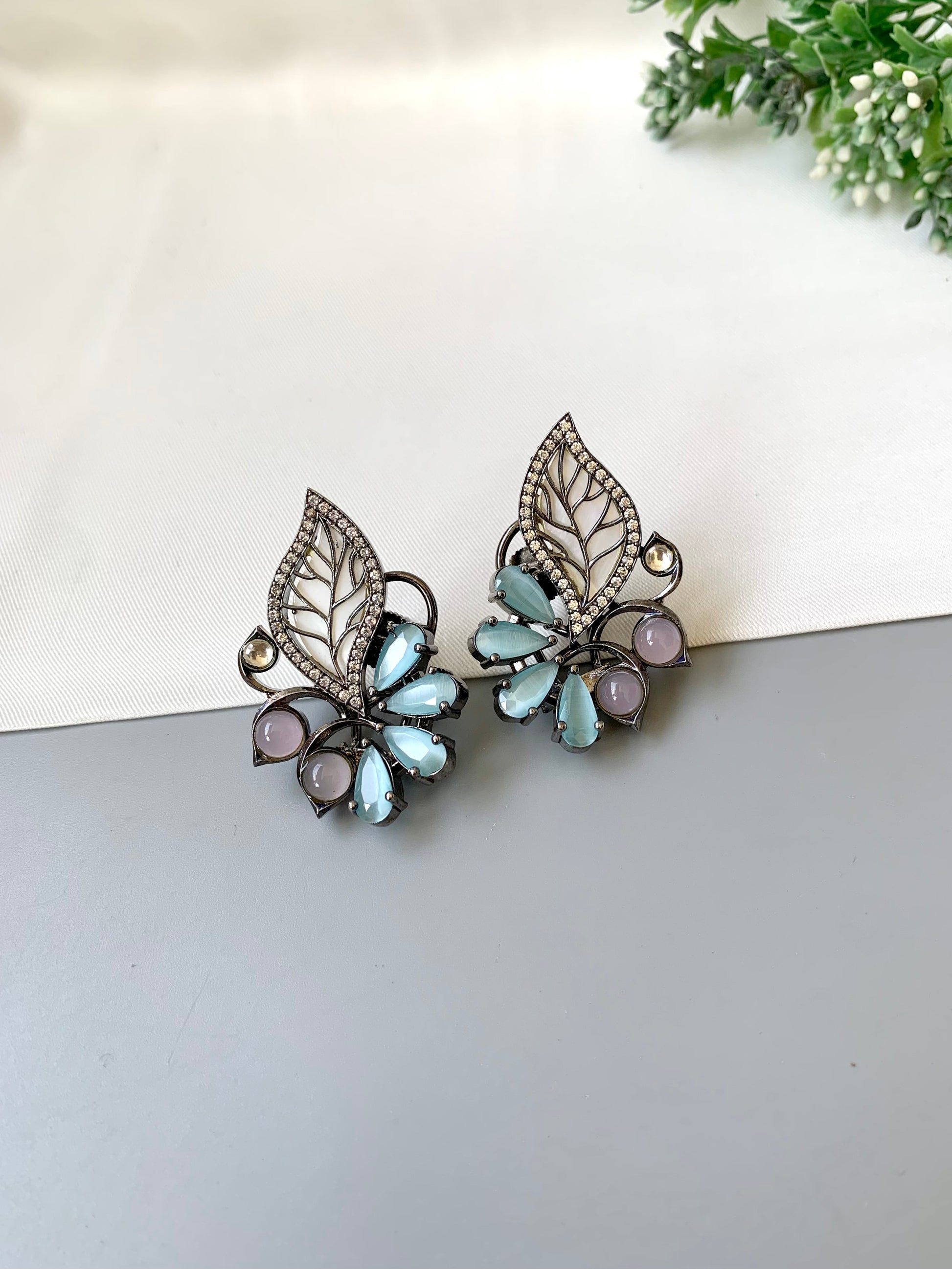 Mina polki kundan studs in rhodium oxidized finish with mother of pearl and onyx stones