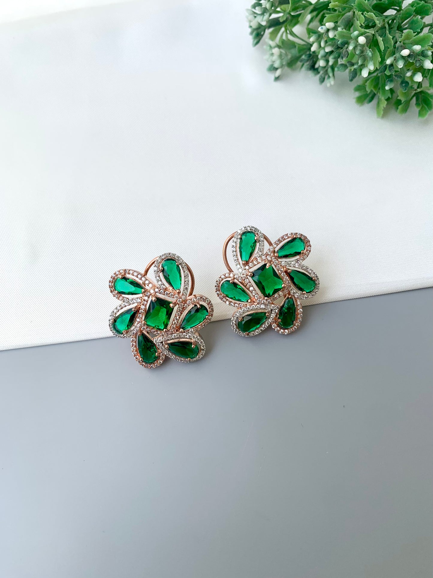Naino rose gold plated studs with American diamonds and emerald accents