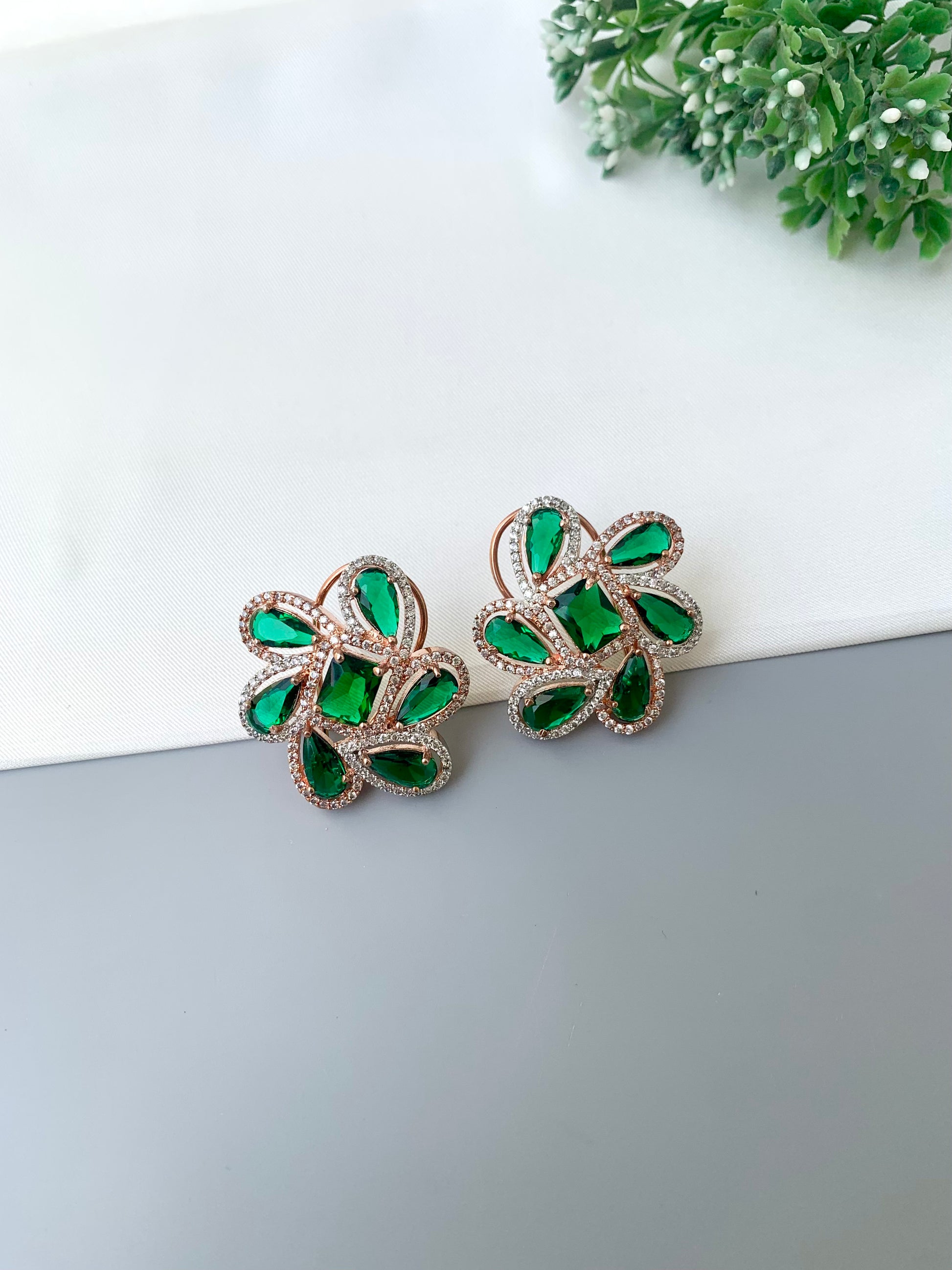 Naino rose gold plated studs with American diamonds and emerald accents