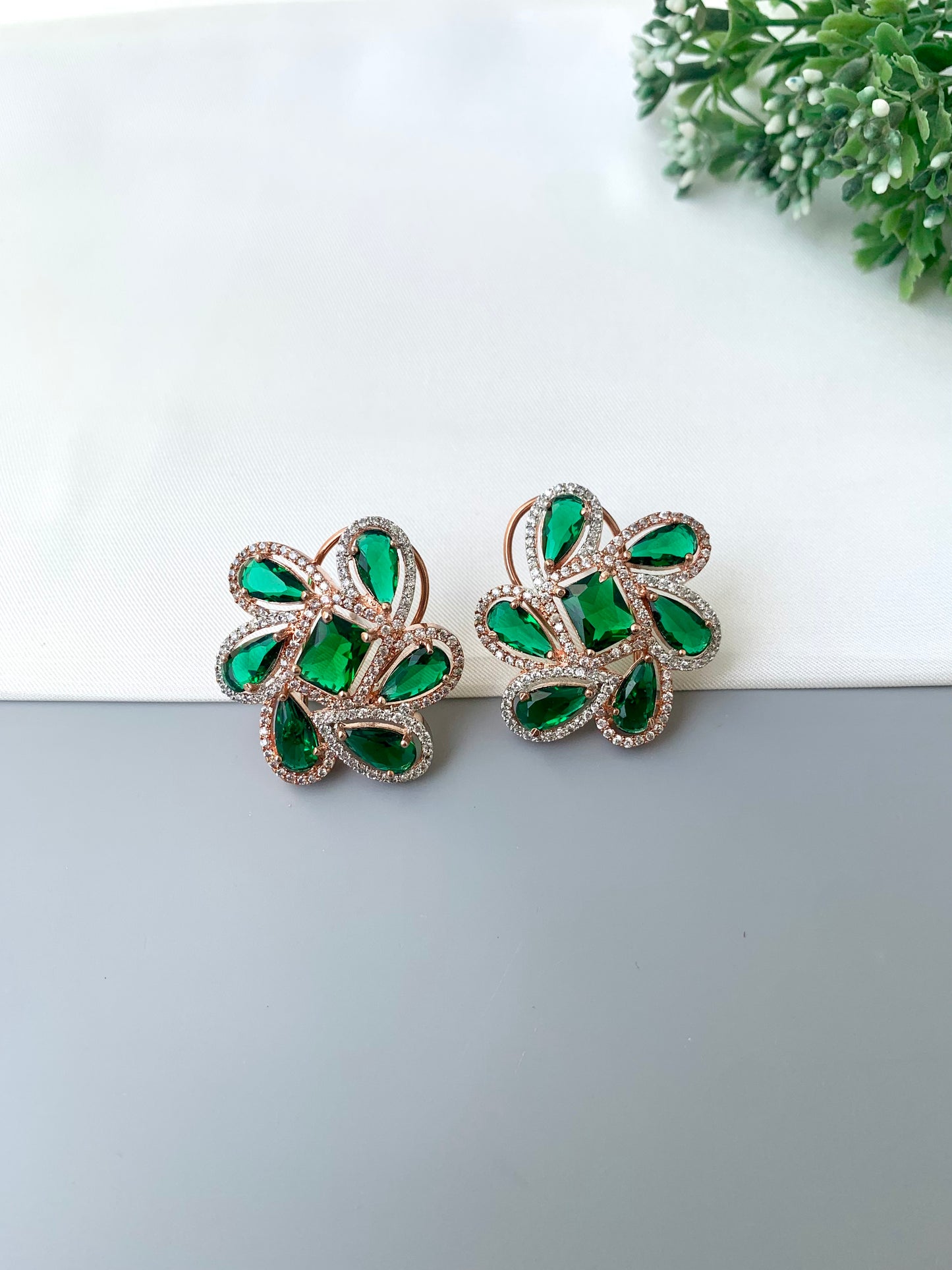 Naino rose gold plated studs with American diamonds and emerald accents