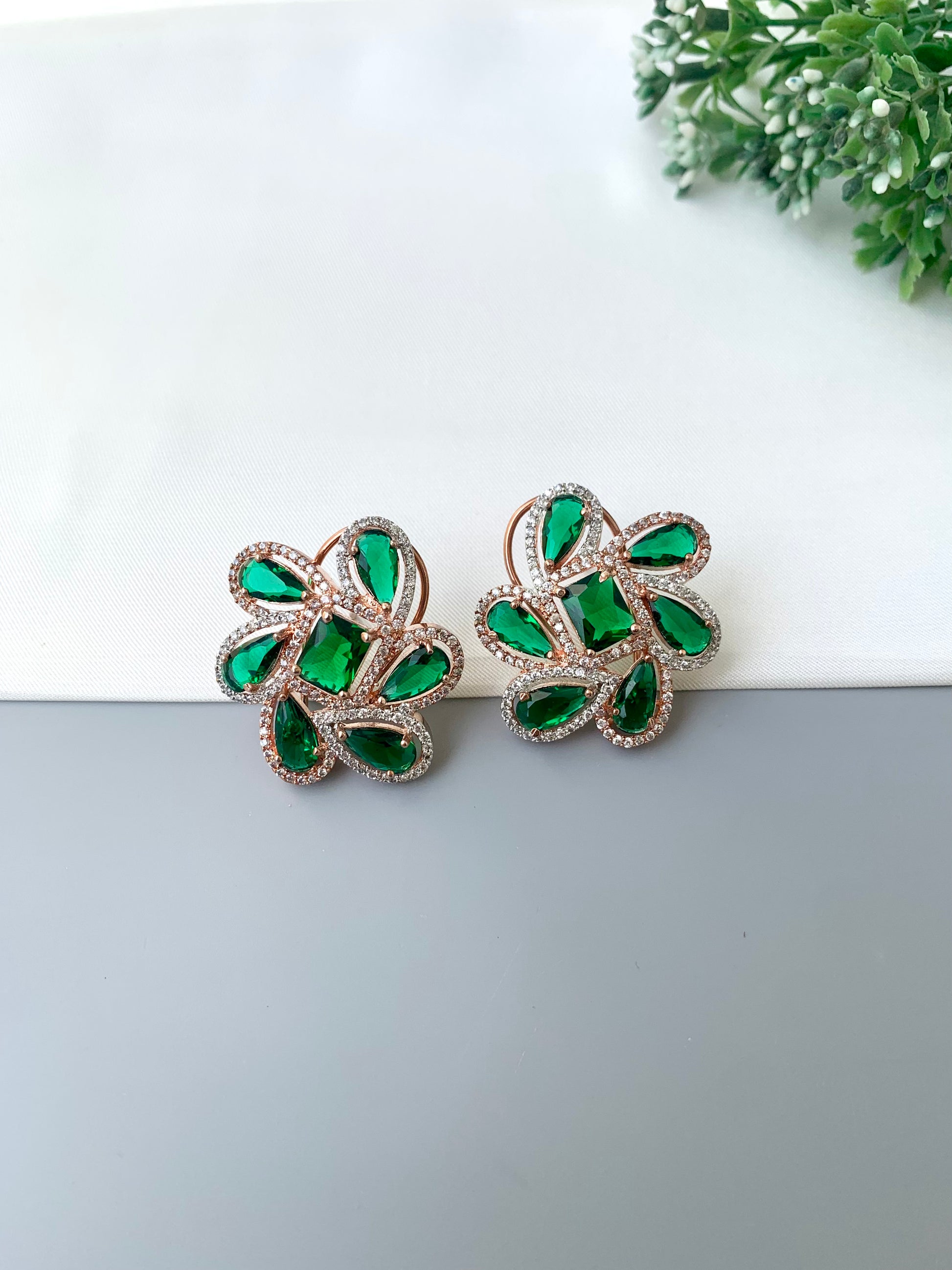 Naino rose gold plated studs with American diamonds and emerald accents
