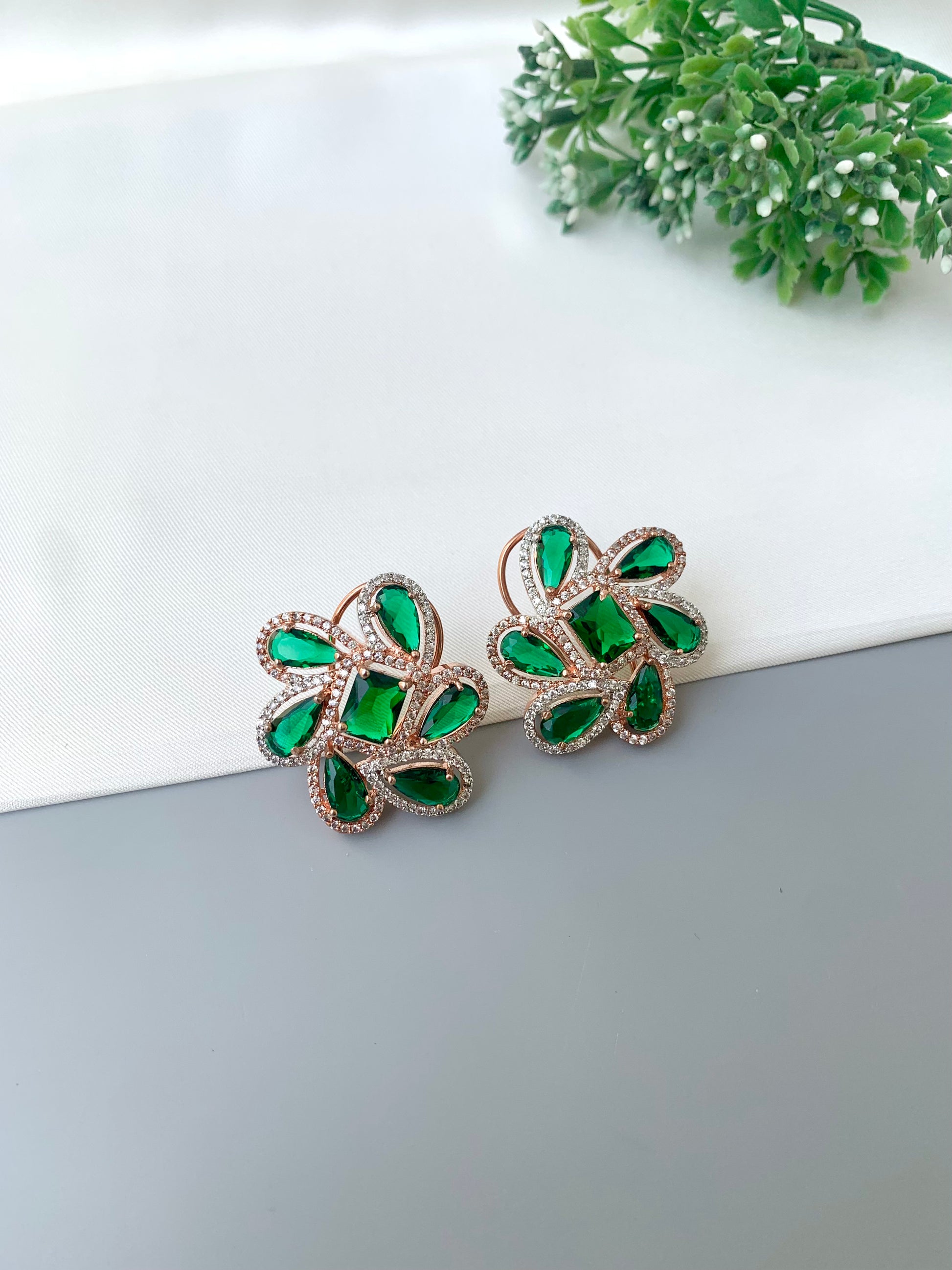 Naino rose gold plated studs with American diamonds and emerald accents