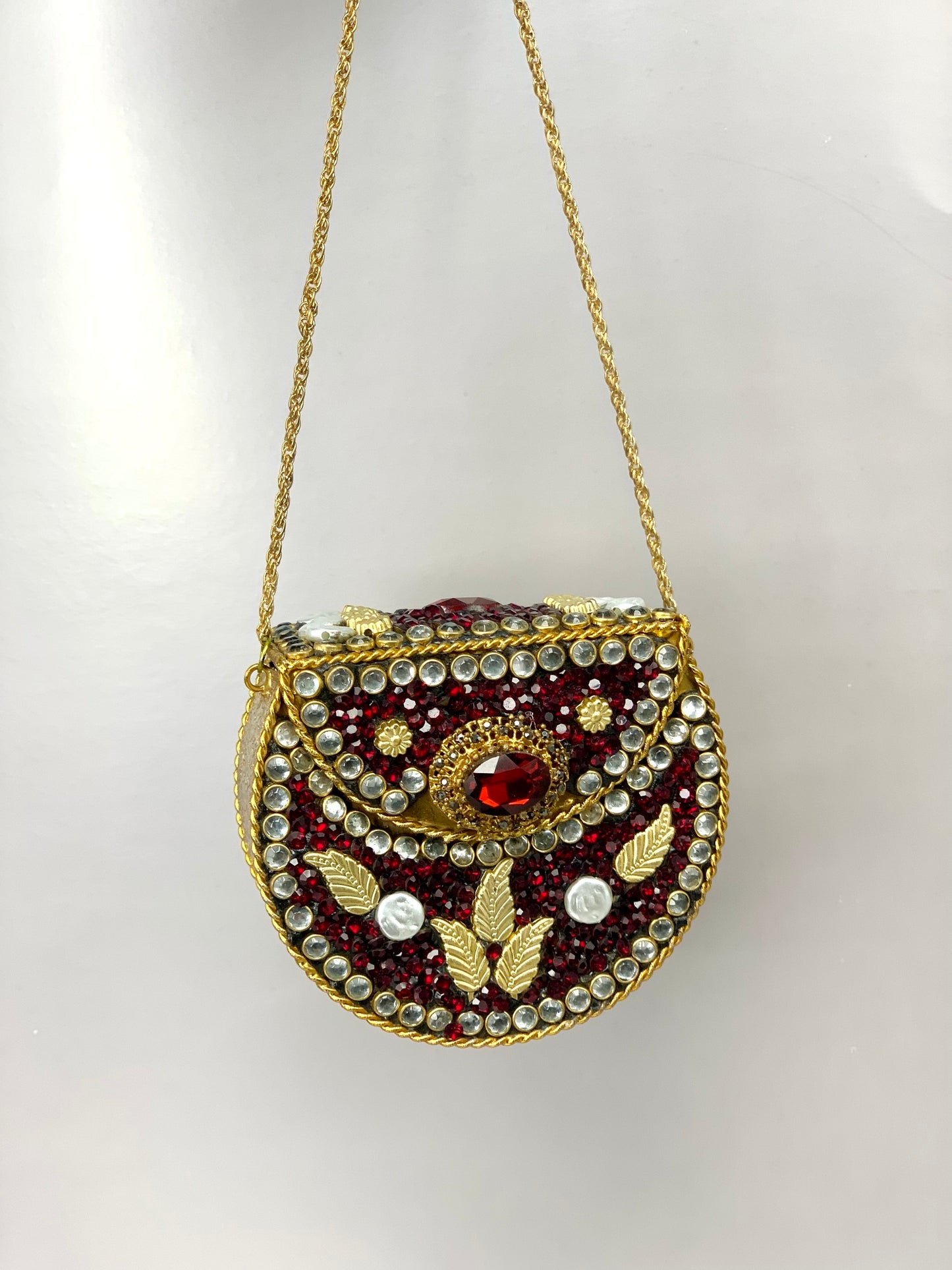 Nayab handcrafted gold plated clutch with kundan rubies pearls and natural gemstone embellishments