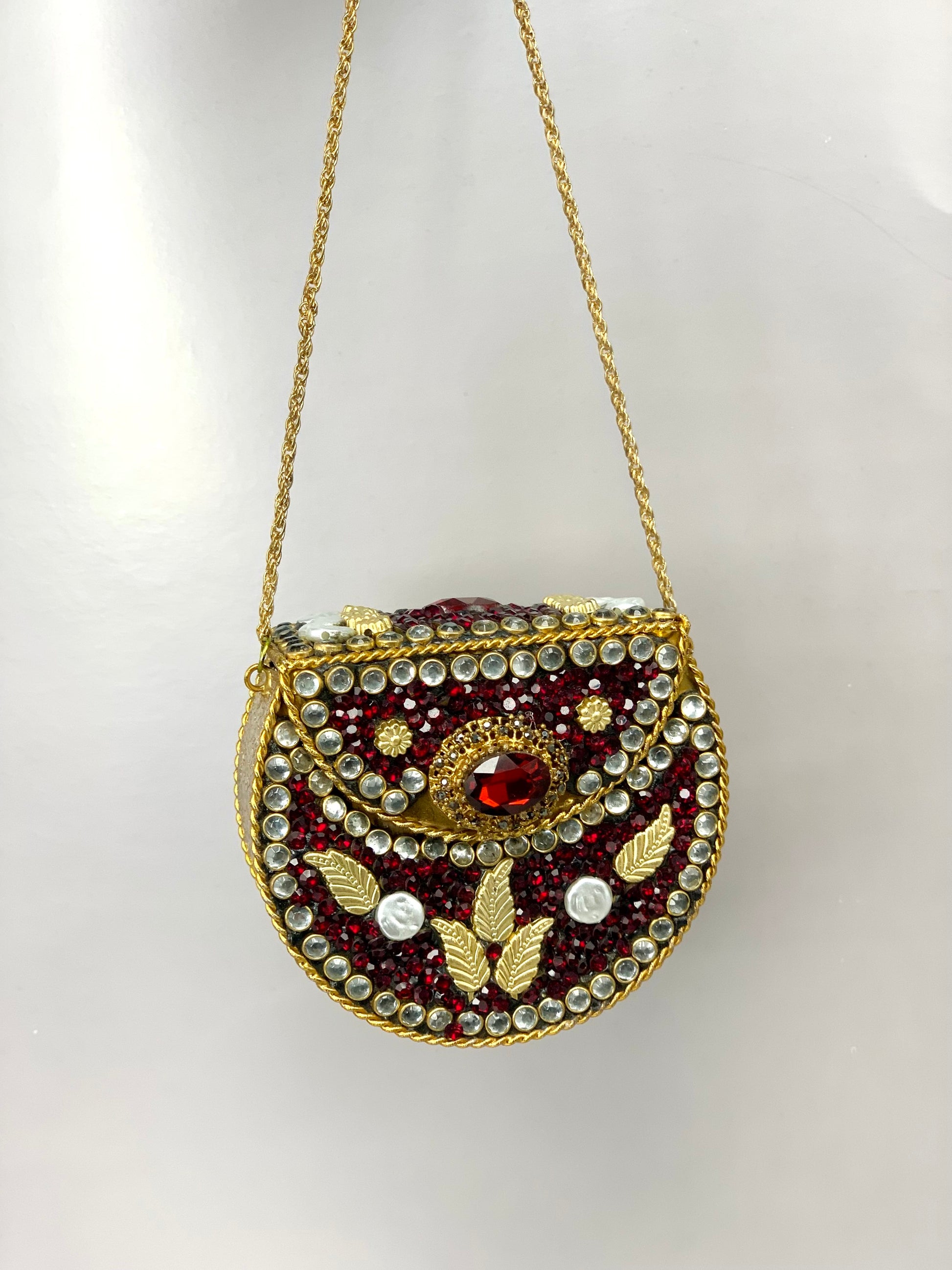 Nayab handcrafted gold plated clutch with kundan rubies pearls and natural gemstone embellishments