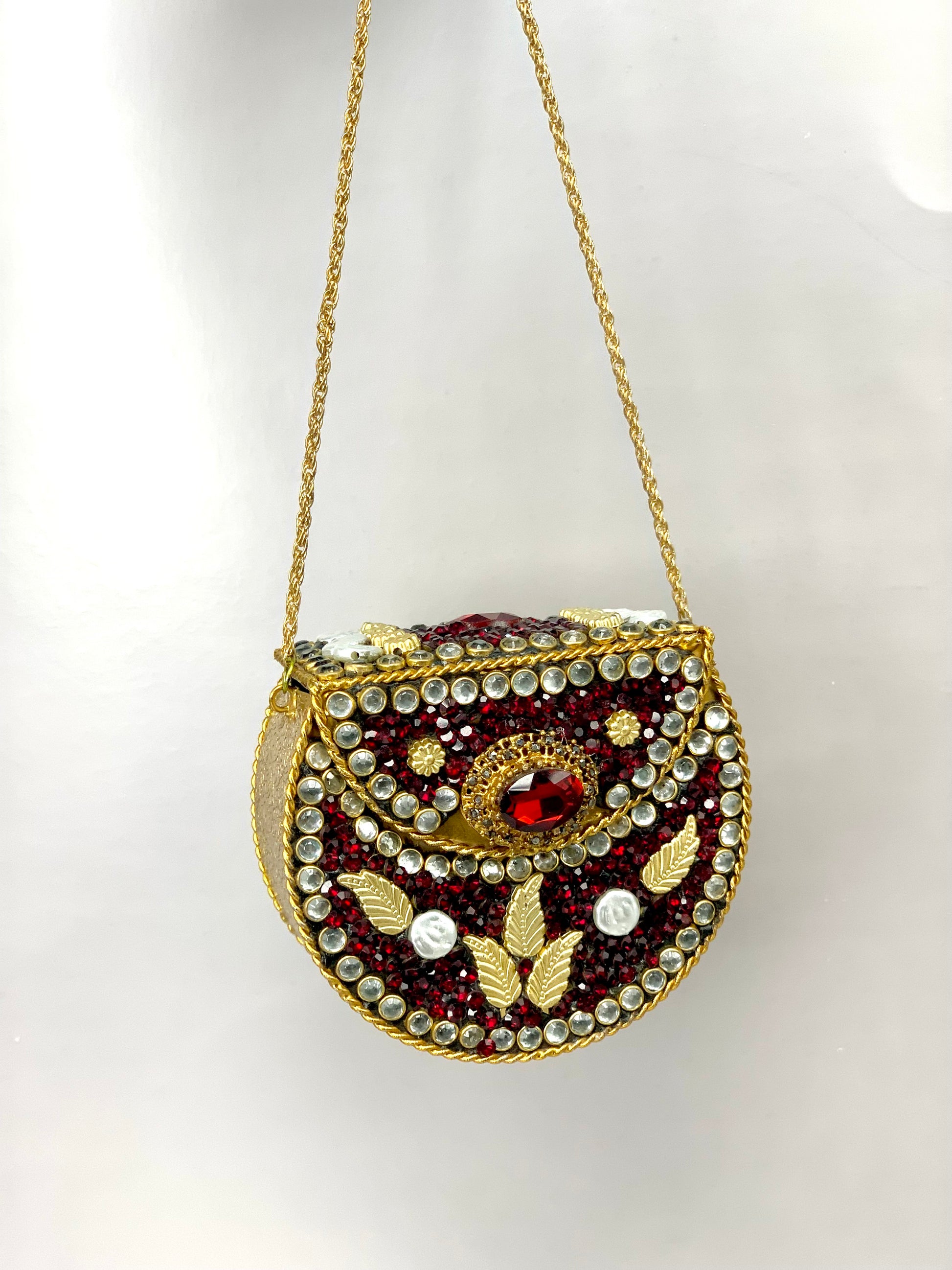 Nayab handcrafted gold plated clutch with kundan rubies pearls and natural gemstone embellishments