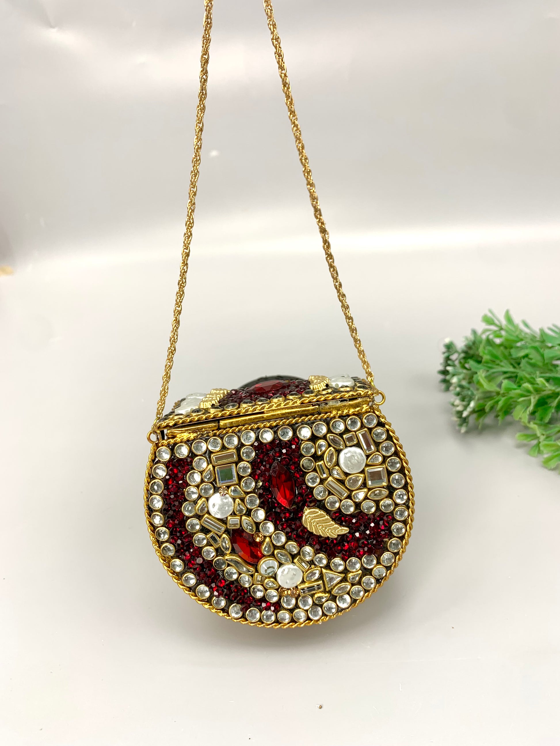 Nayab handcrafted gold plated clutch with kundan rubies pearls and natural gemstone embellishments