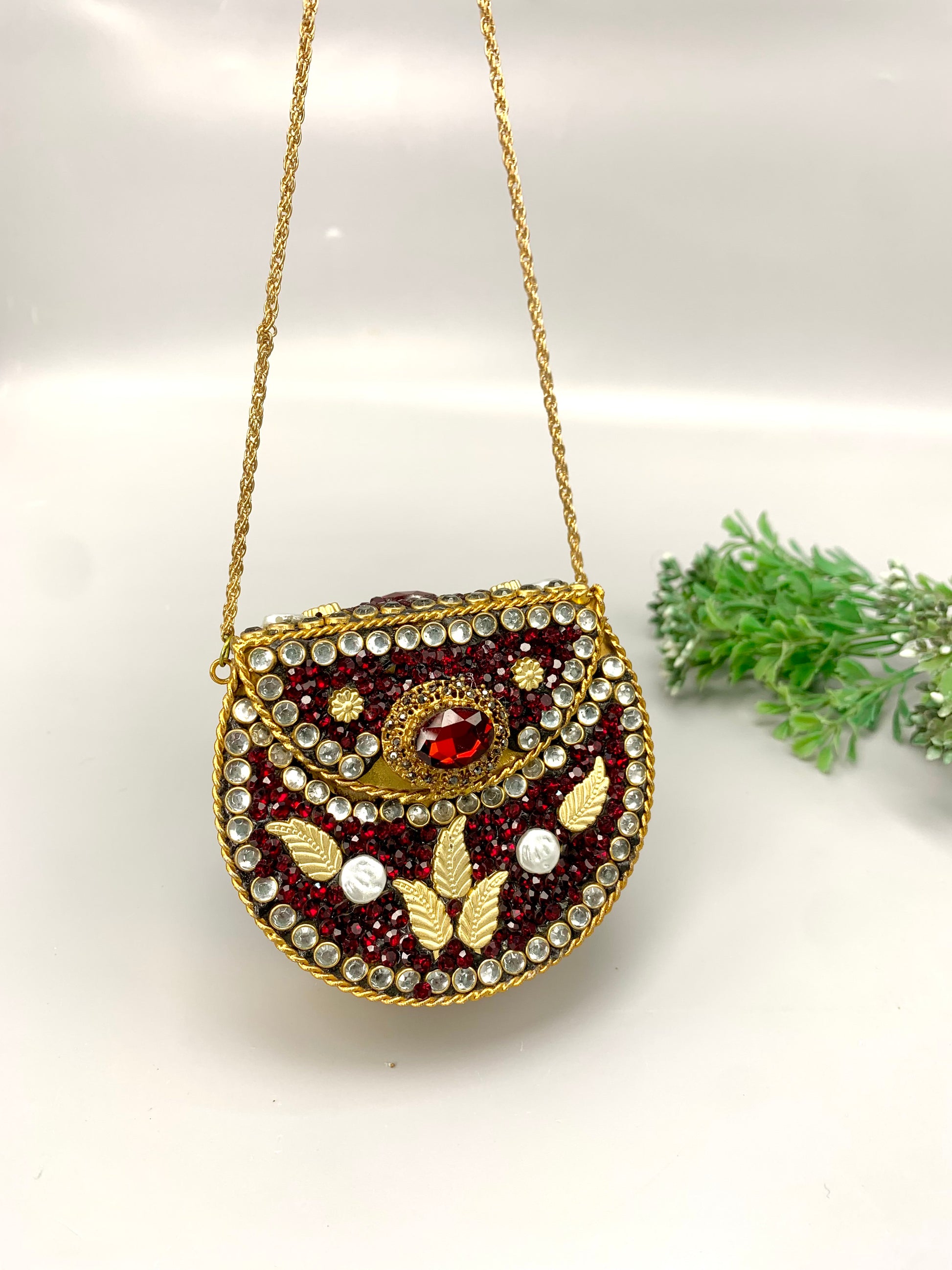 Nayab handcrafted gold plated clutch with kundan rubies pearls and natural gemstone embellishments