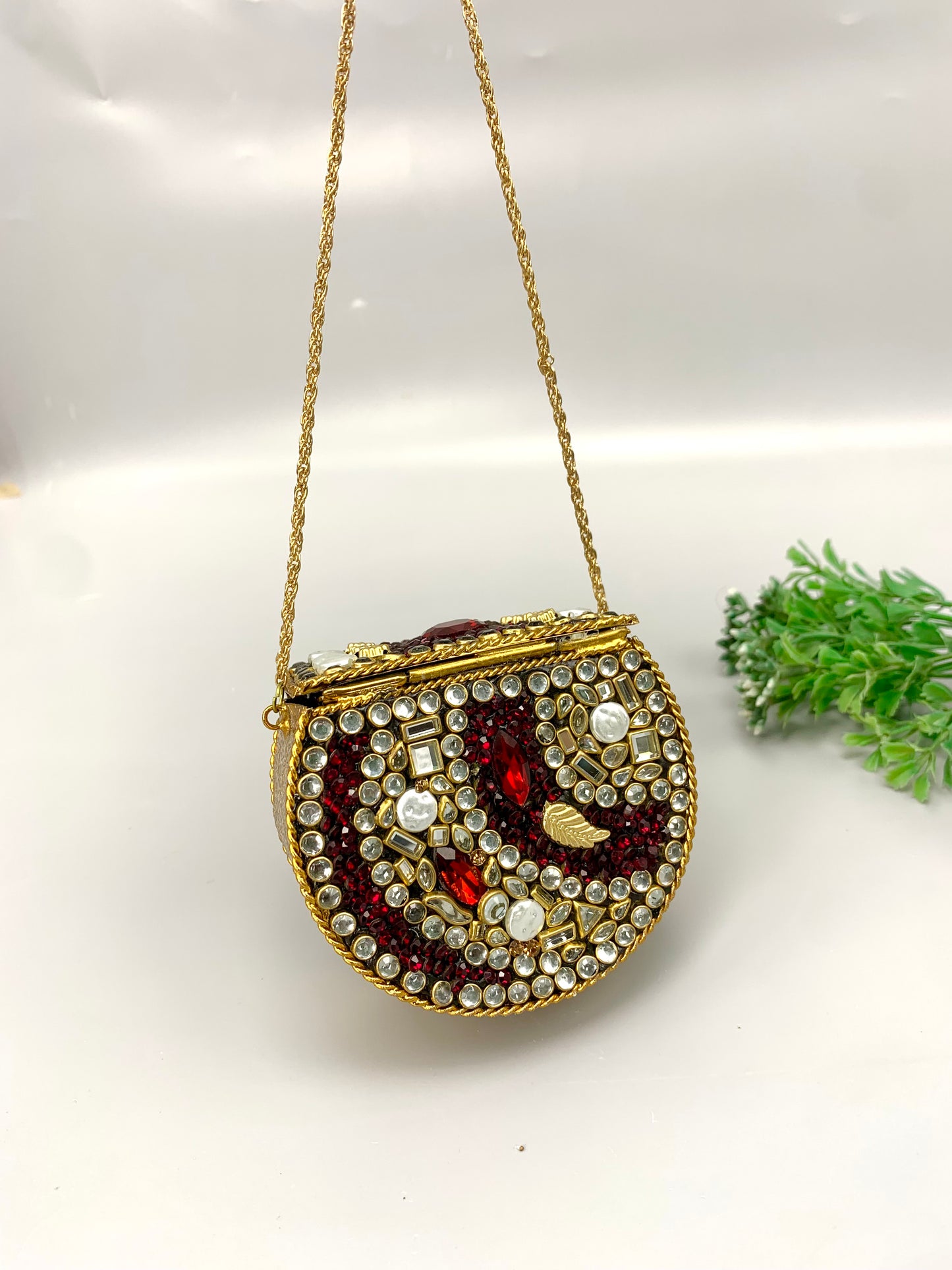 Nayab handcrafted gold plated clutch with kundan rubies pearls and natural gemstone embellishments