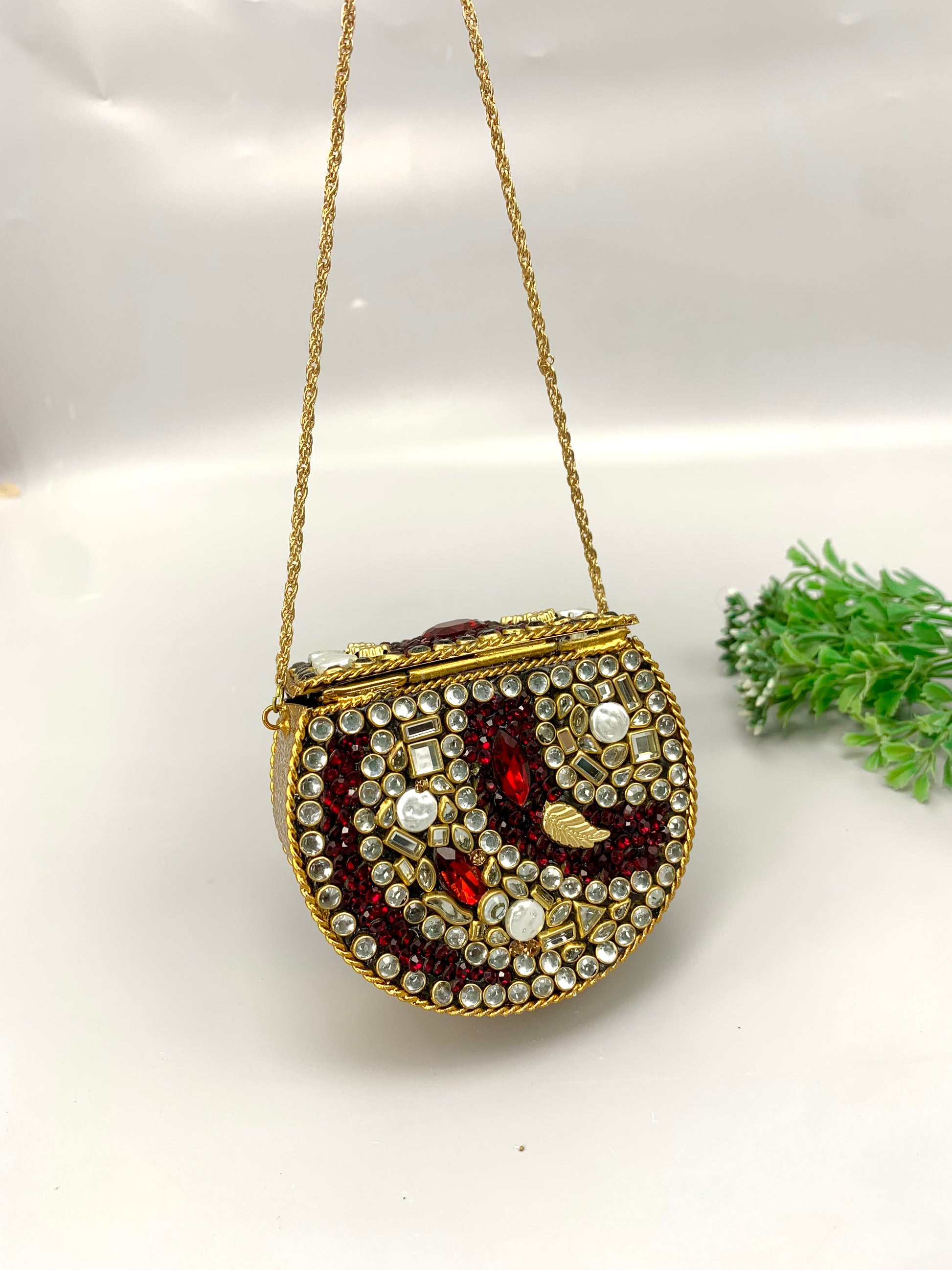 Nayab handcrafted gold plated clutch with kundan rubies pearls and natural gemstone embellishments