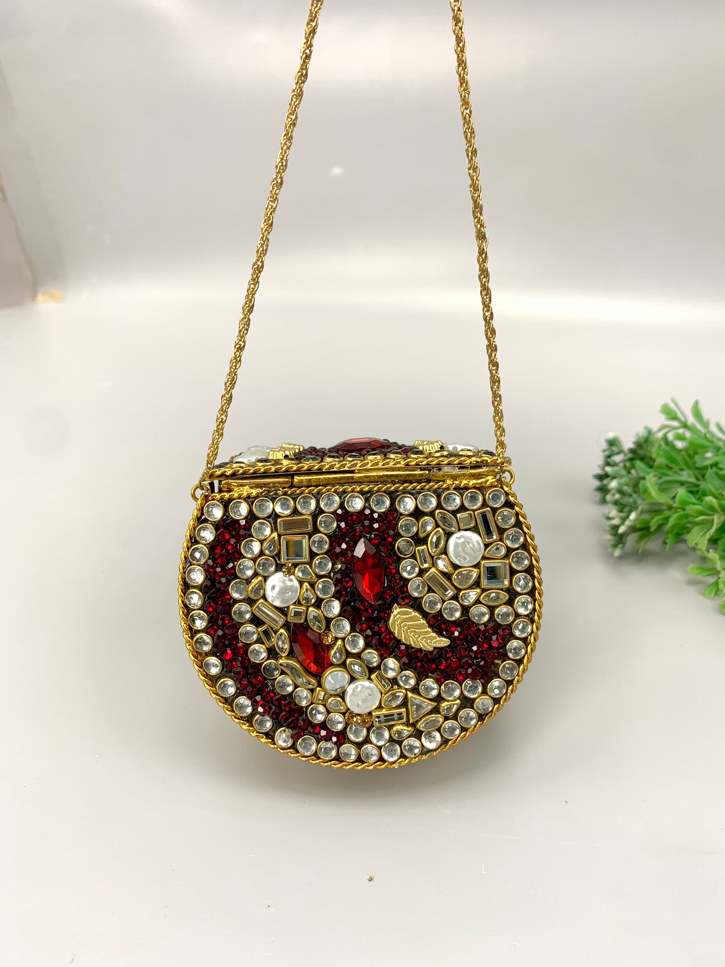 Nayab handcrafted gold plated clutch with kundan rubies pearls and natural gemstone embellishments