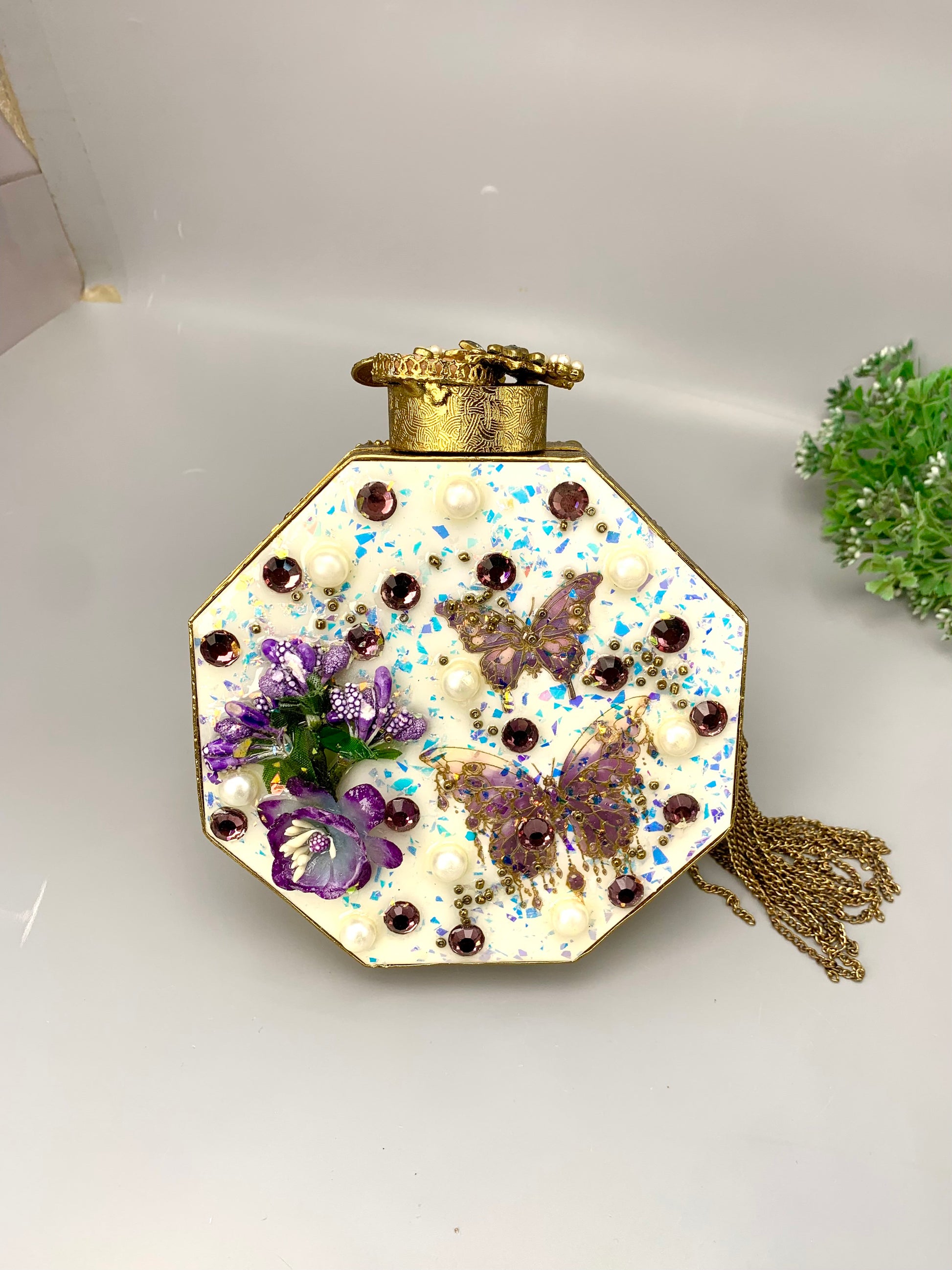 Noor handcrafted gold plated clutch with butterfly and floral gemstone embellishments