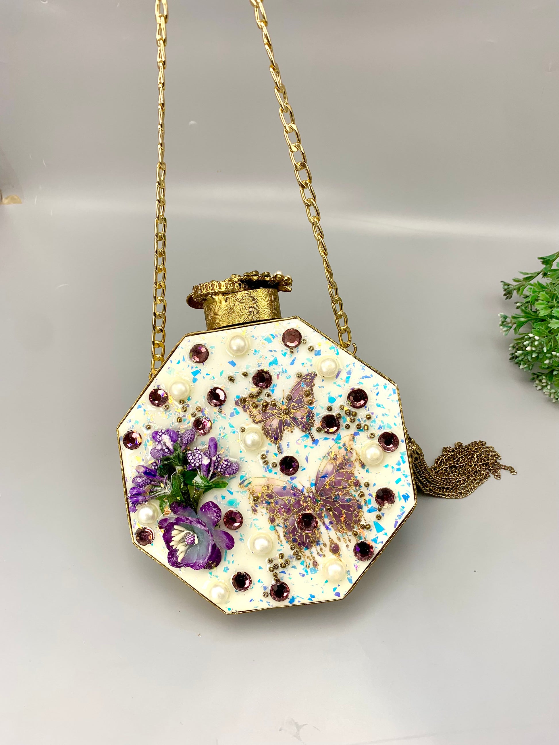 Noor handcrafted gold plated clutch with butterfly and floral gemstone embellishments