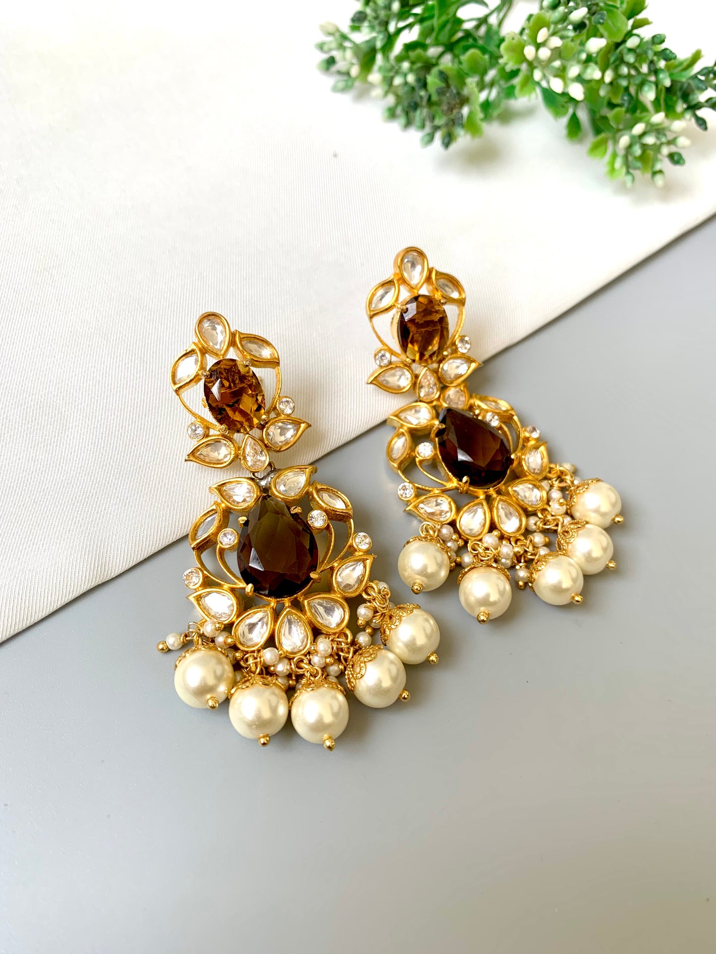 Bridal-style gold plated earrings with brown stone centerpiece, pearl hangings and intricate Kundan work