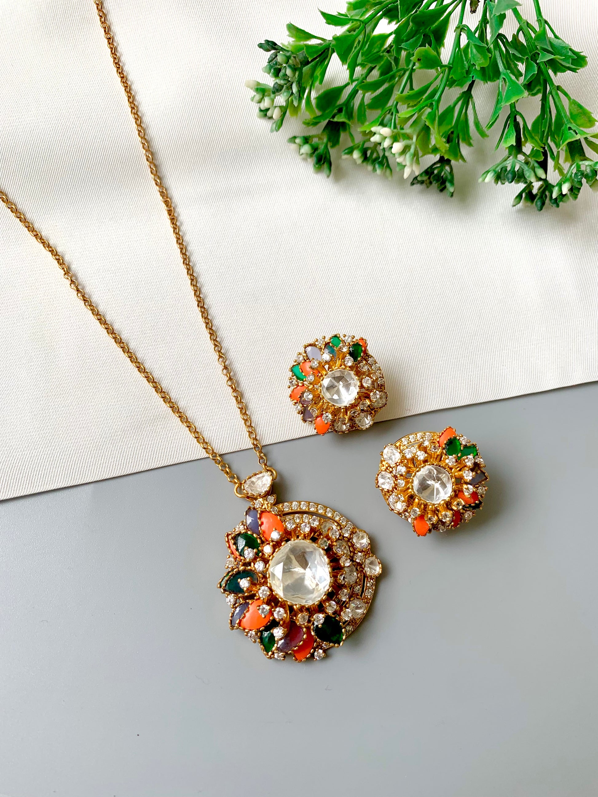 "Angled view of the Raniyah multicolor pendant set with floral design and matching earrings by Zamal Jewels"