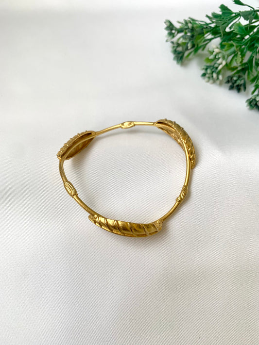 Rishani geometric gold bangle in curved triangular shape with hand carved leaf design