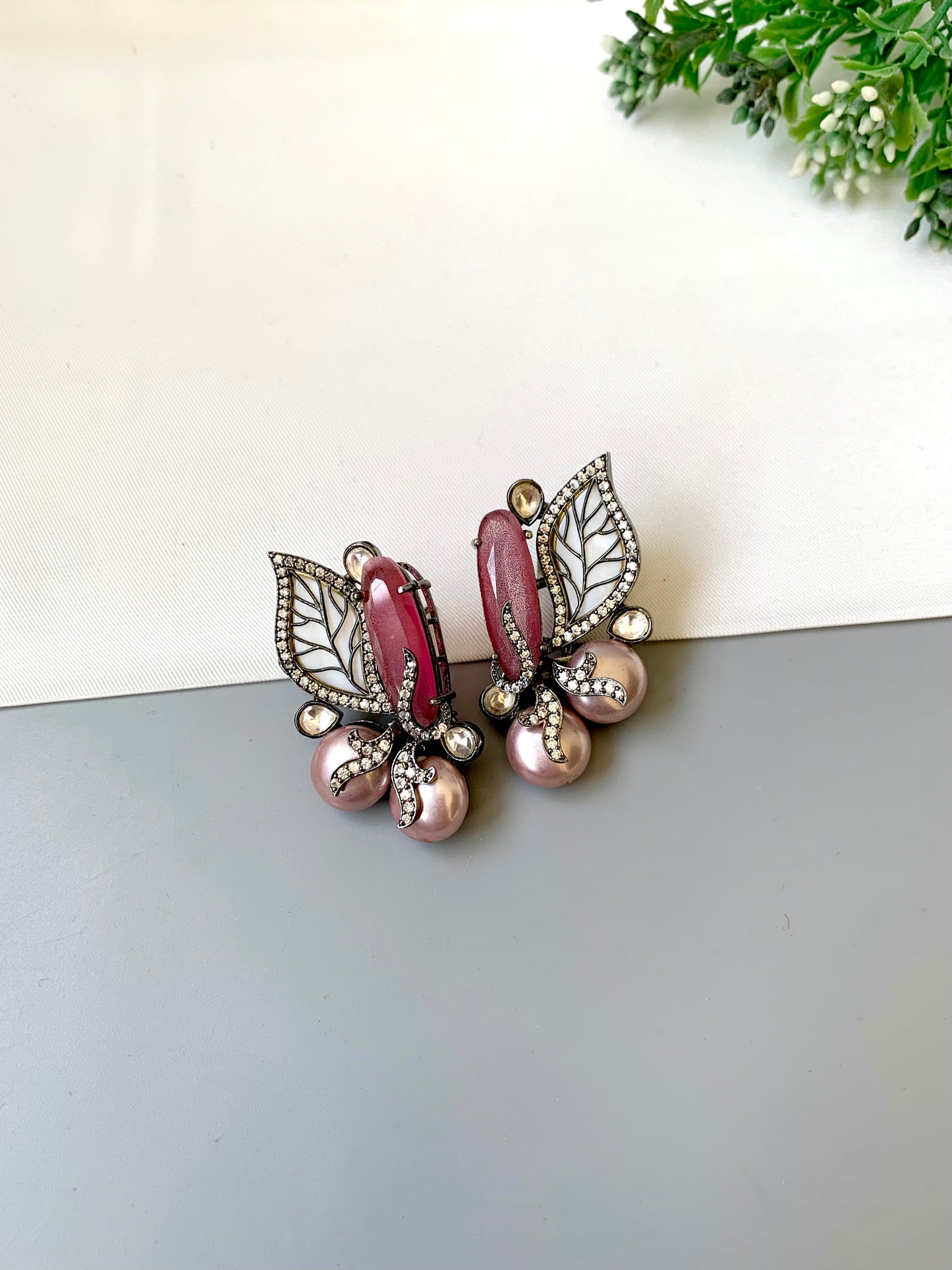 Saga pink studs in rhodium plating with polki kundan, baroque pearls and mother of pearl