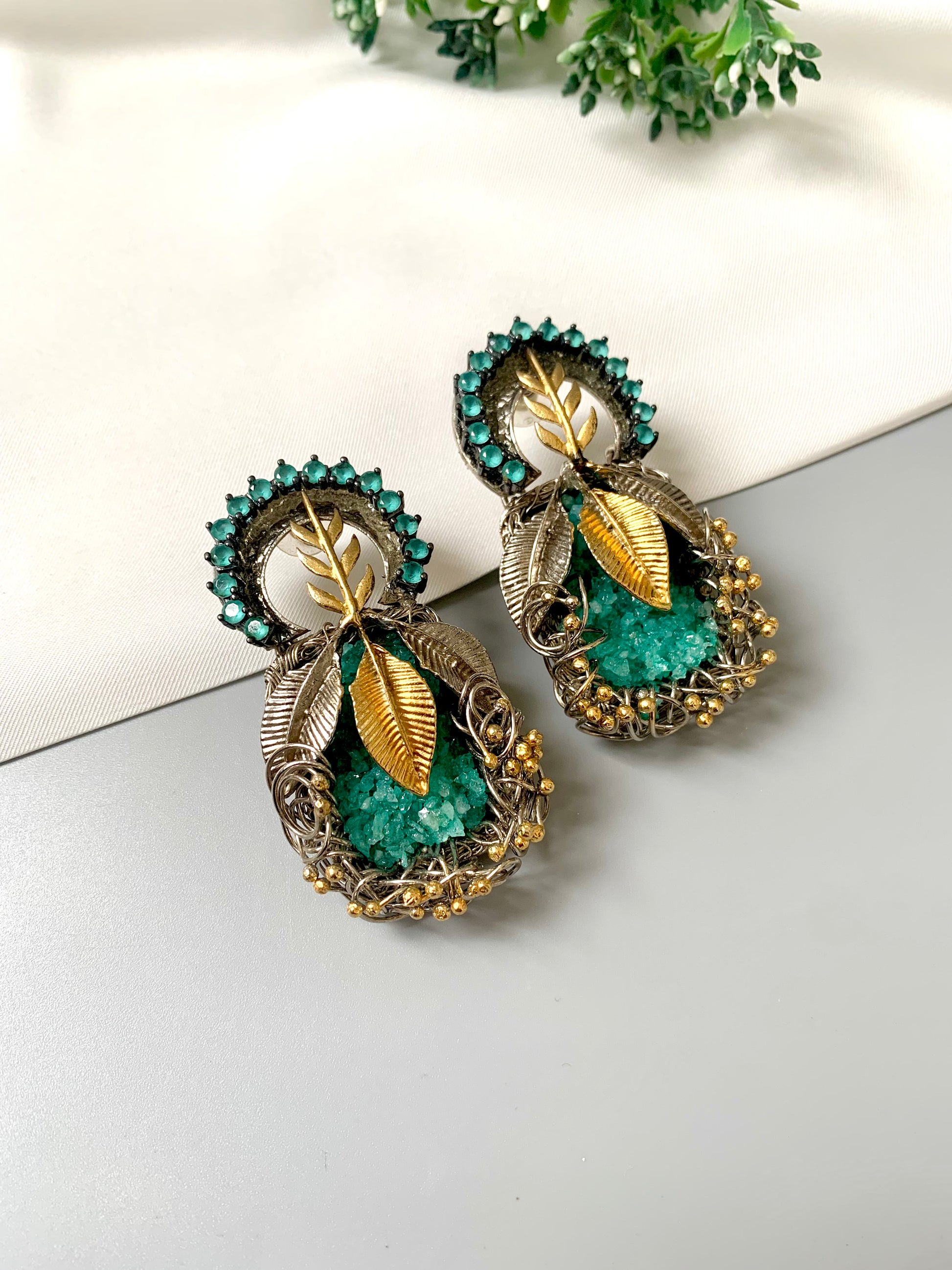 Rhodium plated handcrafted earrings with semi-precious green gemstones and metallic leaf accents from Zamal Jewels