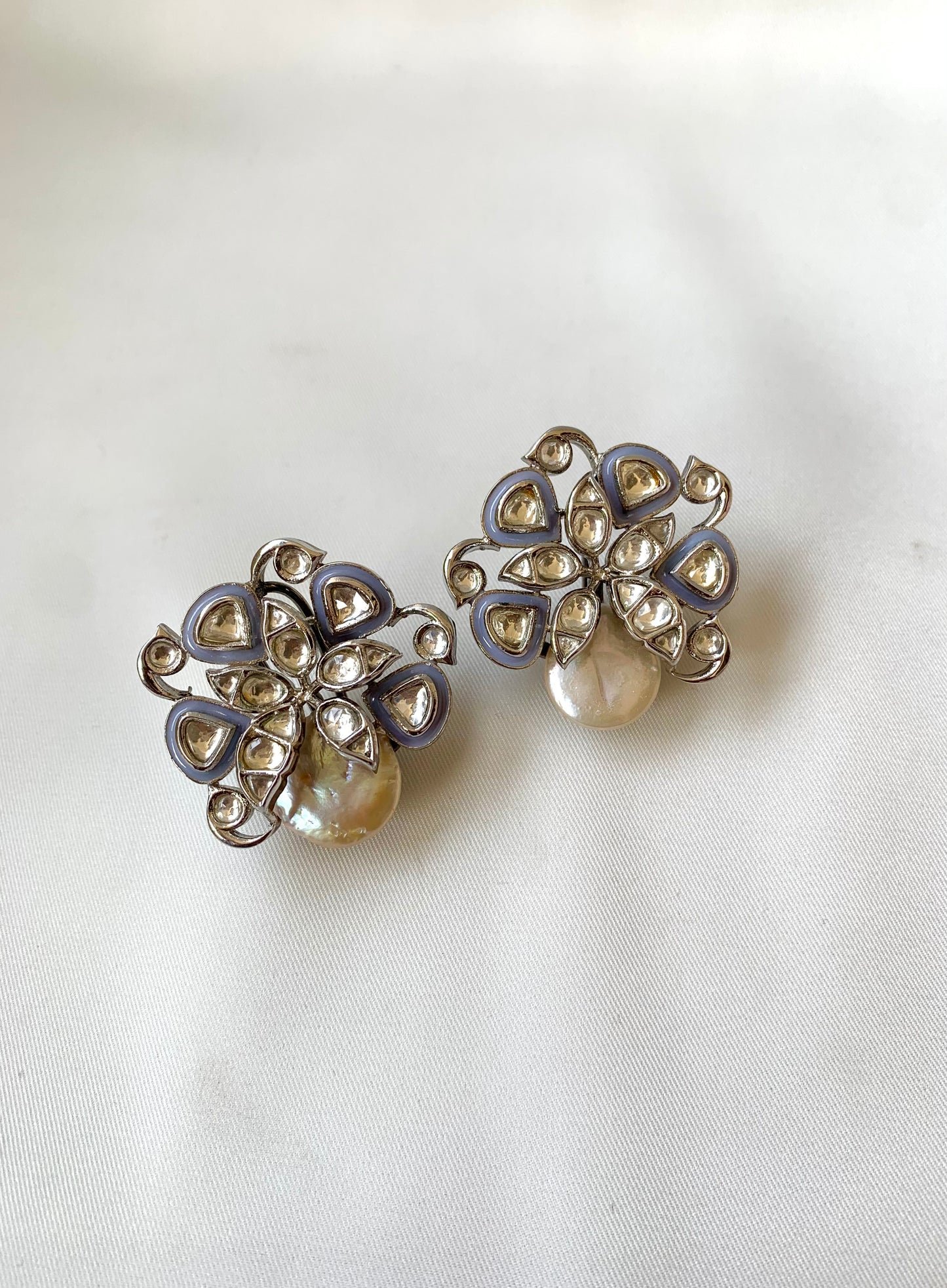 Pair of silver and pearl earrings on a white background