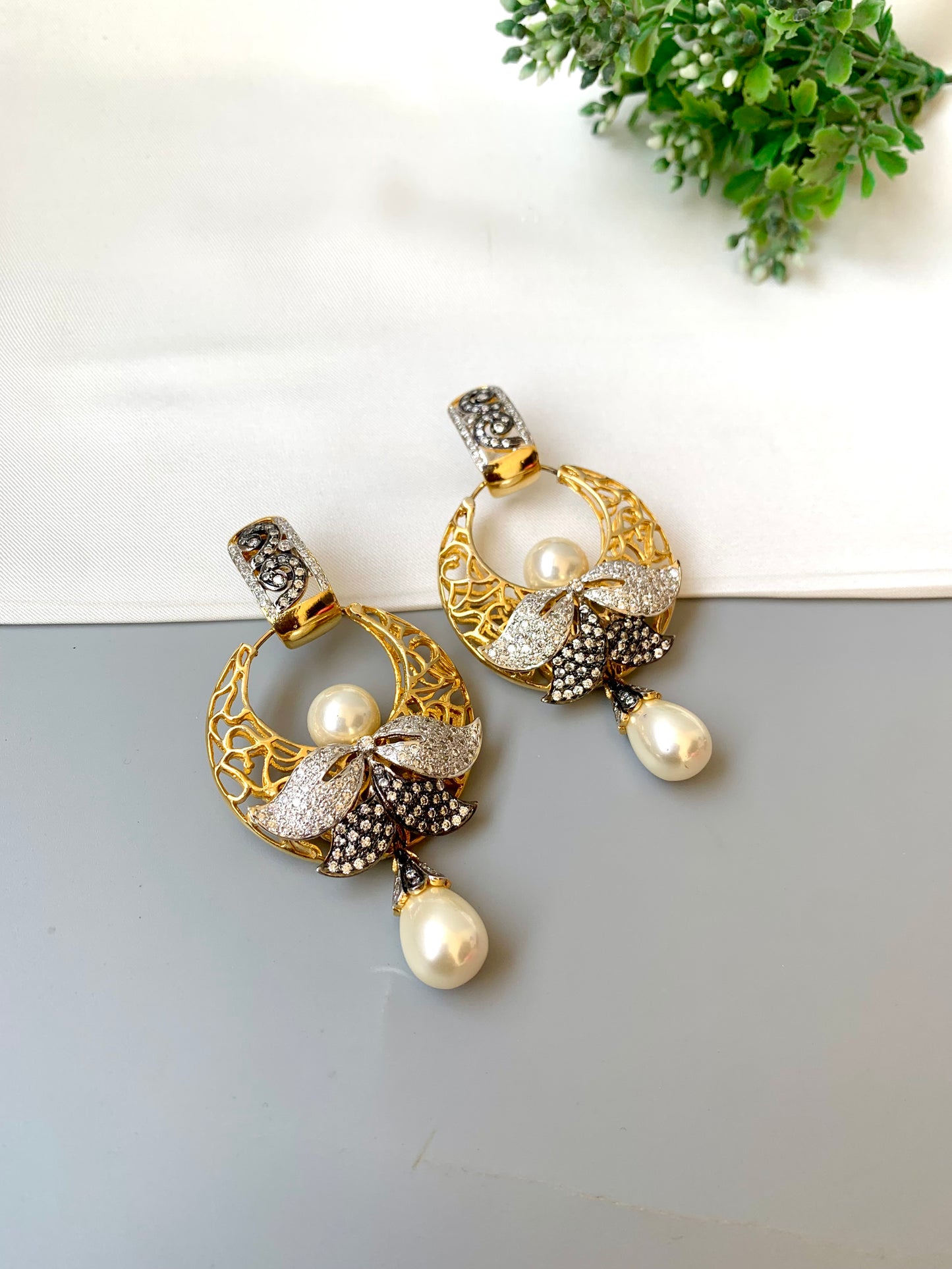Sohai designer earrings in 22kt gold plating with oxidized polish, american diamonds and semi precious pearls