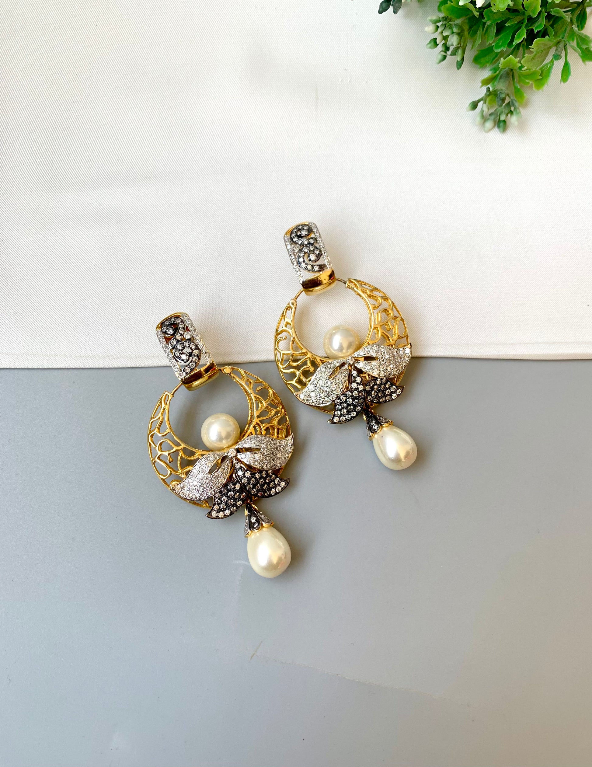 Sohai designer earrings in 22kt gold plating with oxidized polish, american diamonds and semi precious pearls