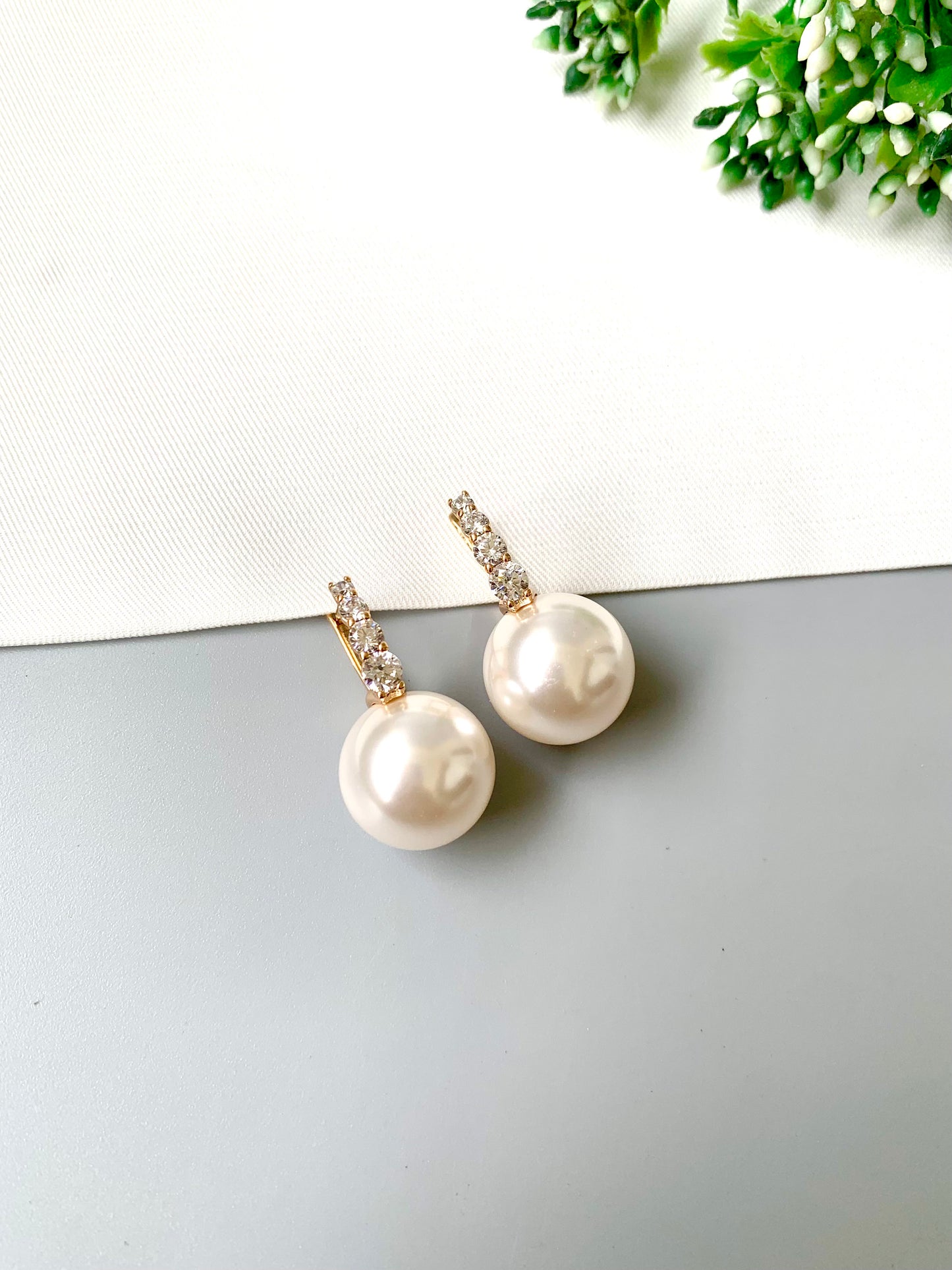 Solene pearl earrings with delicate stone setting – flat lay view
